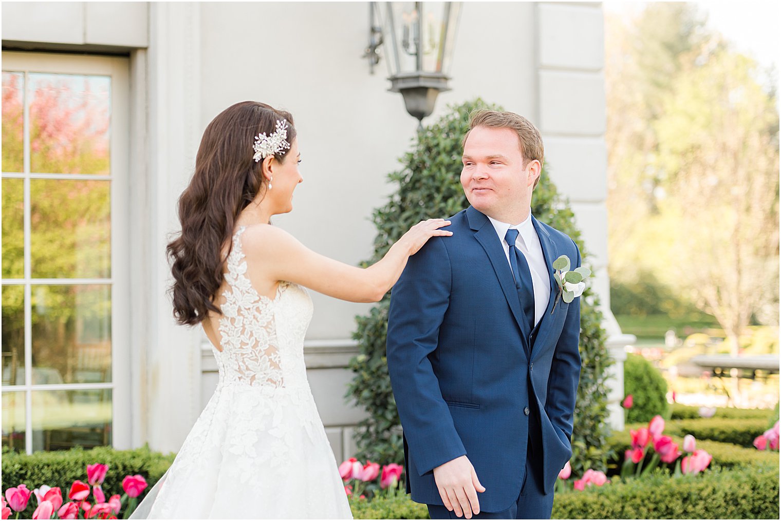 bride reaches out for groom during first look at Park Chateau Estate and Gardens