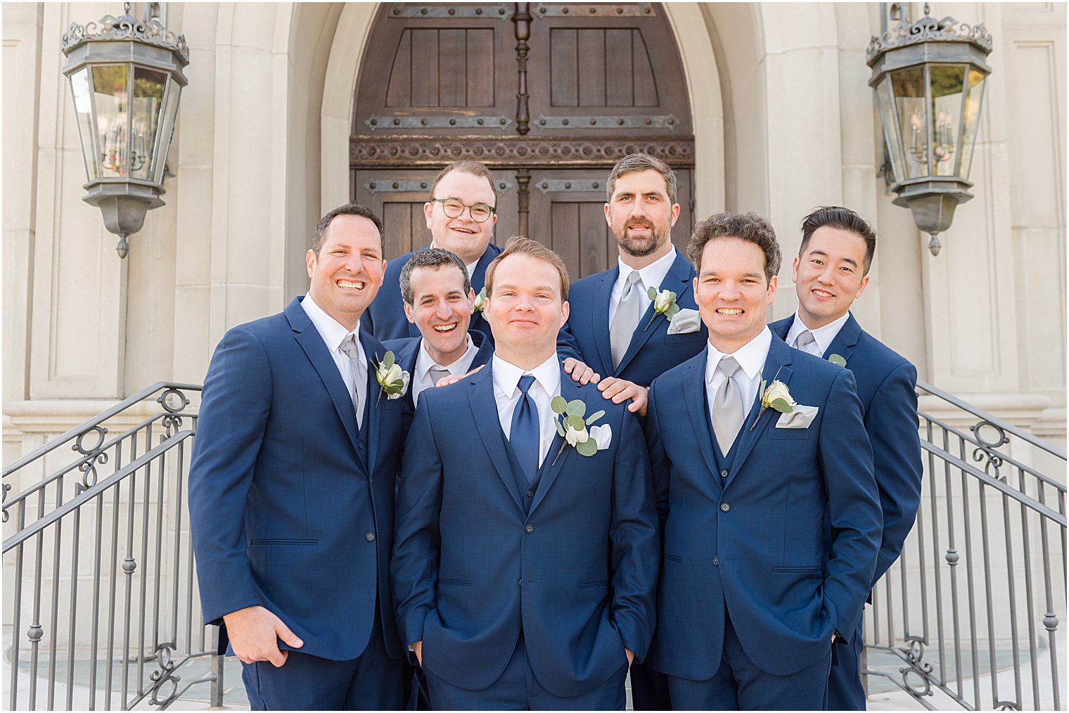 groom poses with groomsmen in blue suits at Park Chateau Estate and Gardens