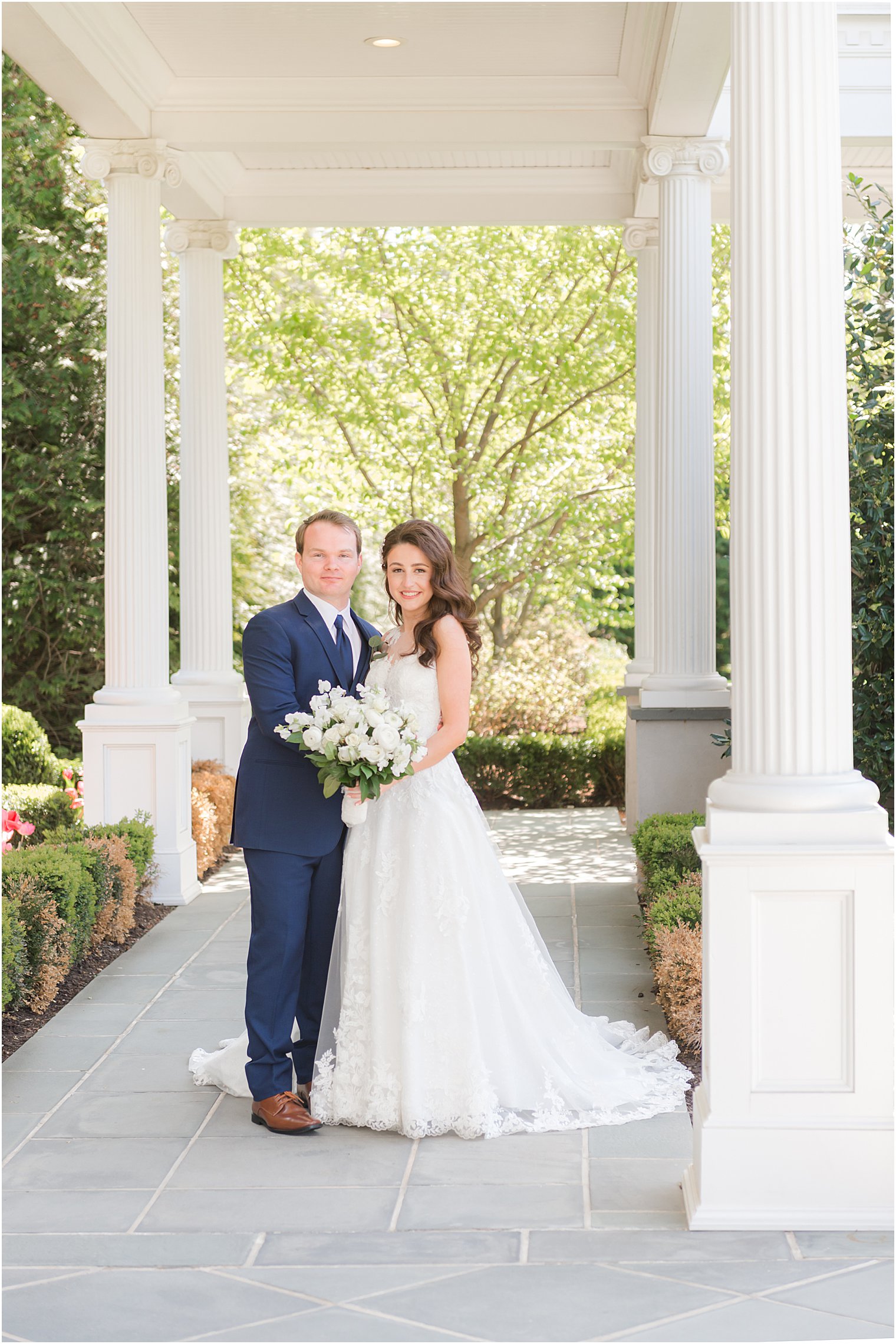 bride and groom pose under walkway at Park Chateau Estate