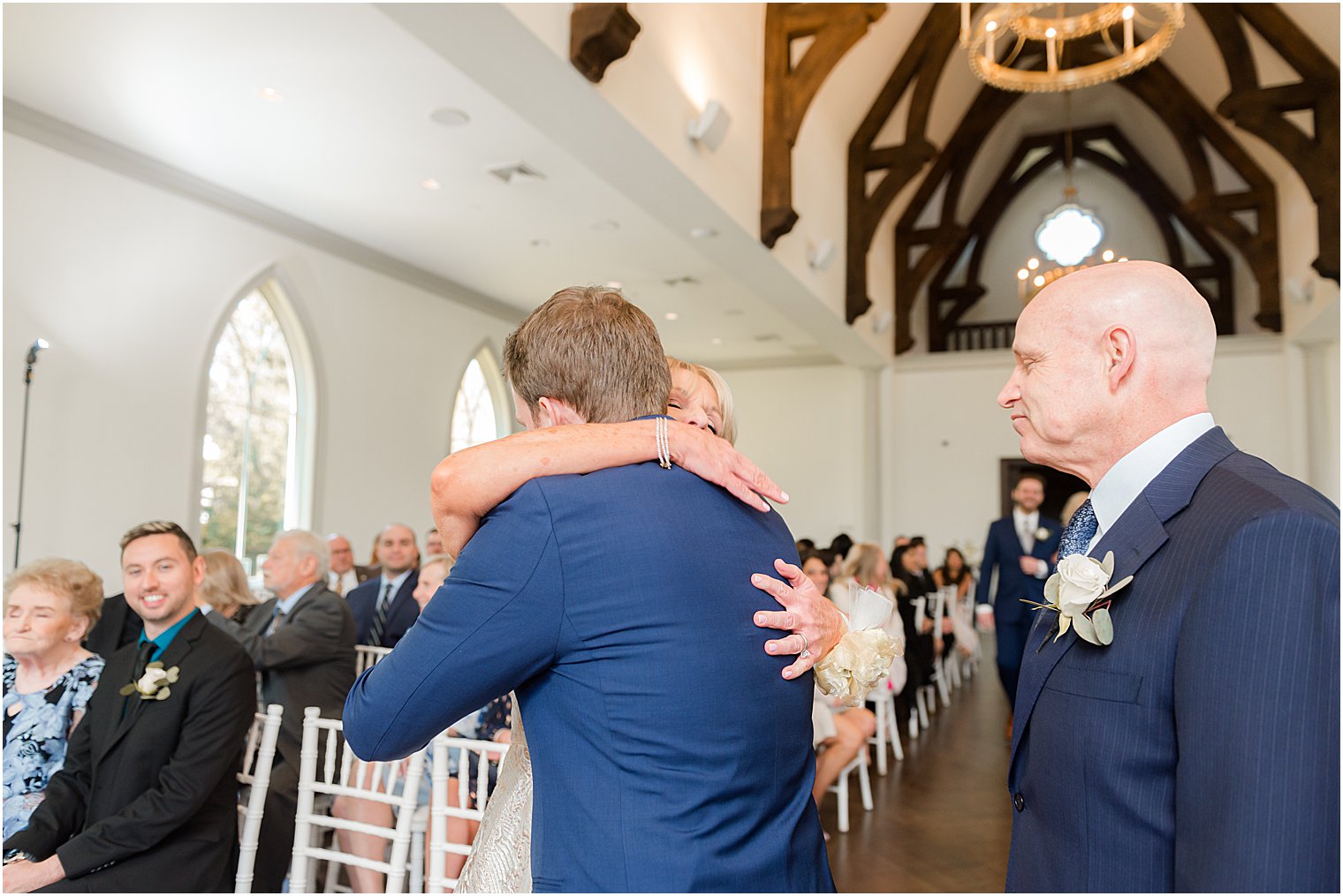 mother hugs groom during wedding ceremony in chapel at Park Chateau Estate