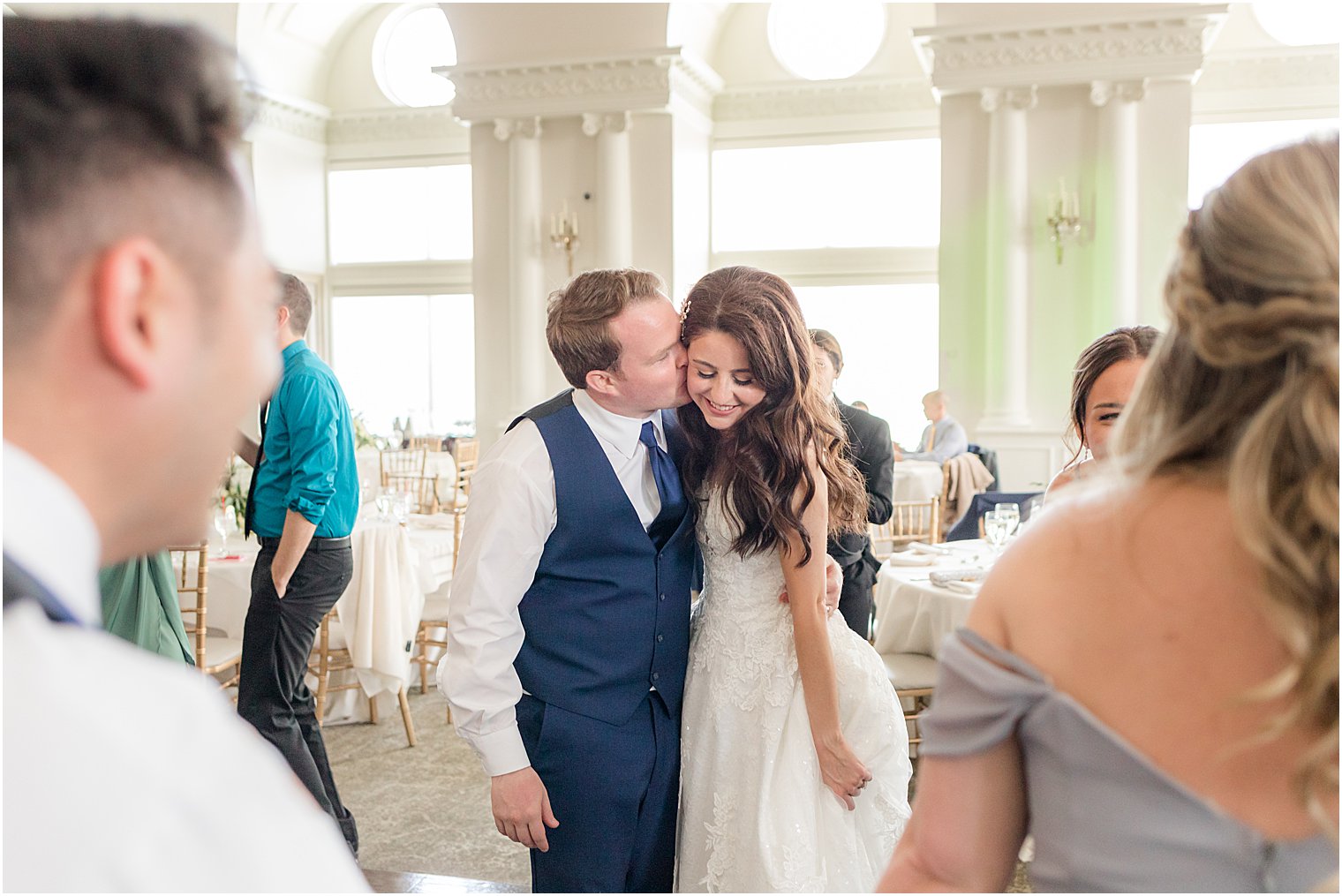 groom kisses bride's cheek during East Brunswick, NJ wedding reception 
