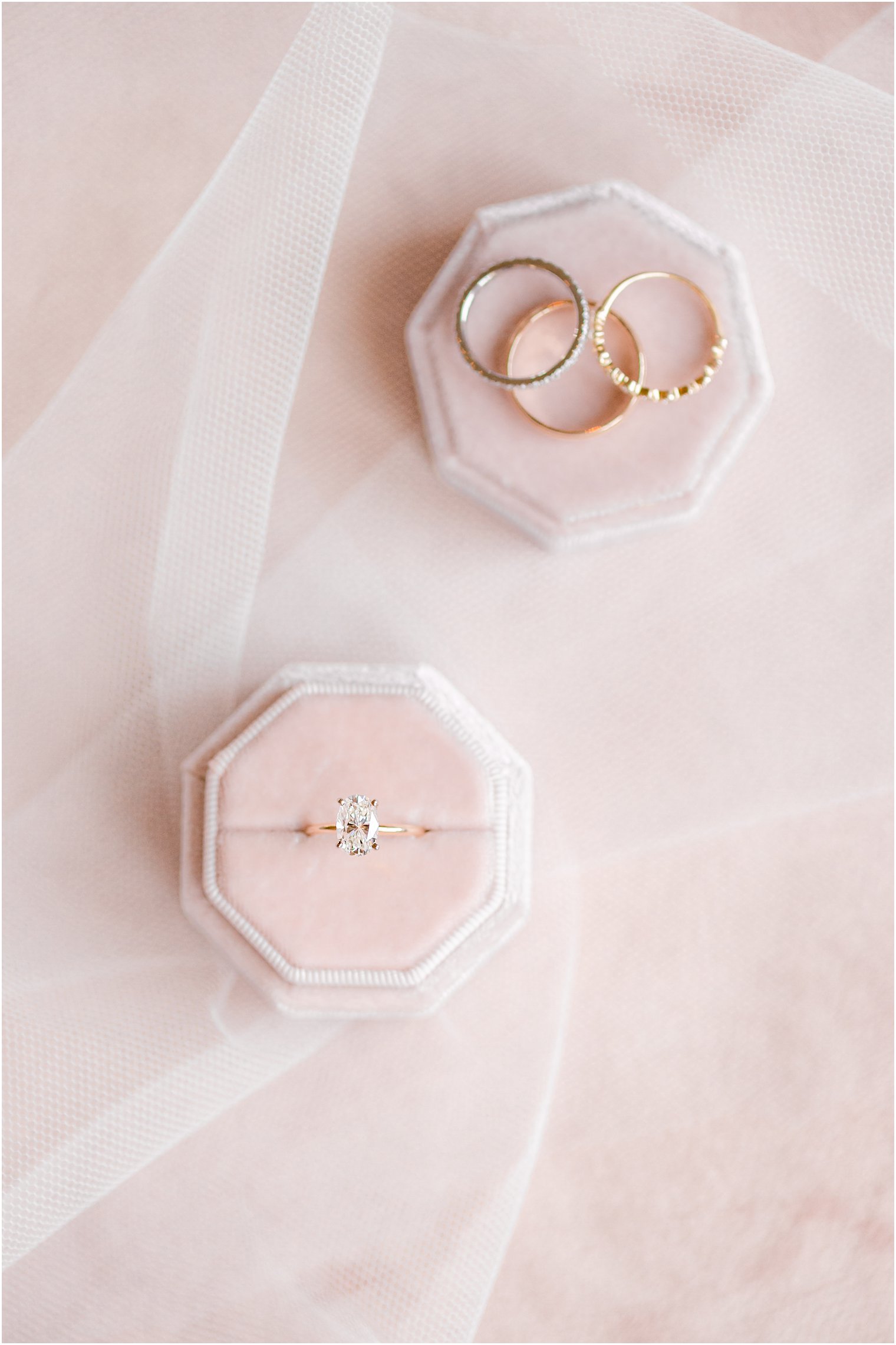 gold and diamond engagement ring rests in pale pink ring box