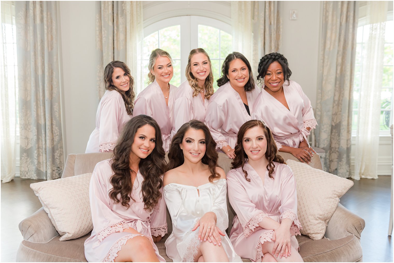 bride sits with bridesmaids in pink robes at Park Chateau Estate