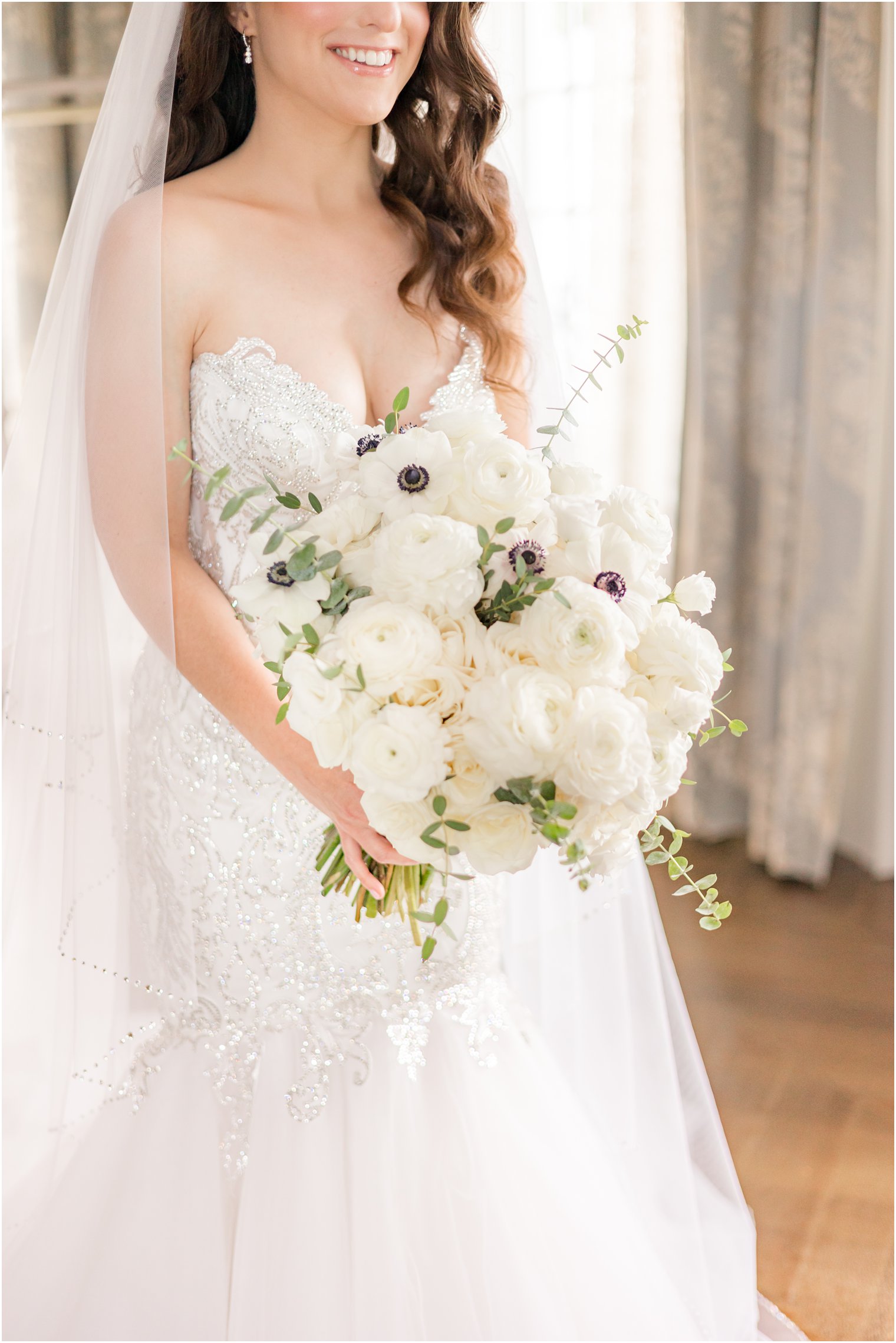 bride poses in mermaid gown with all-ivory bouquet in bridal suite at Park Chateau Estate