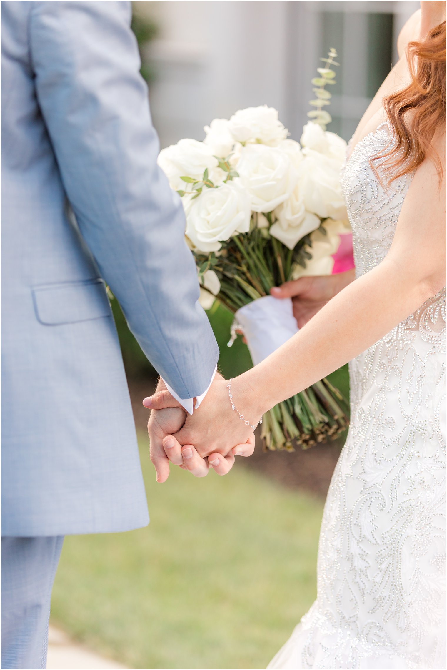 bride and groom hold hands while walking 