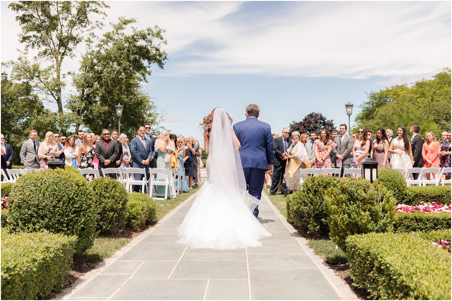 father in navy suit with black edges walks with bride down aisle at Park Chateau 