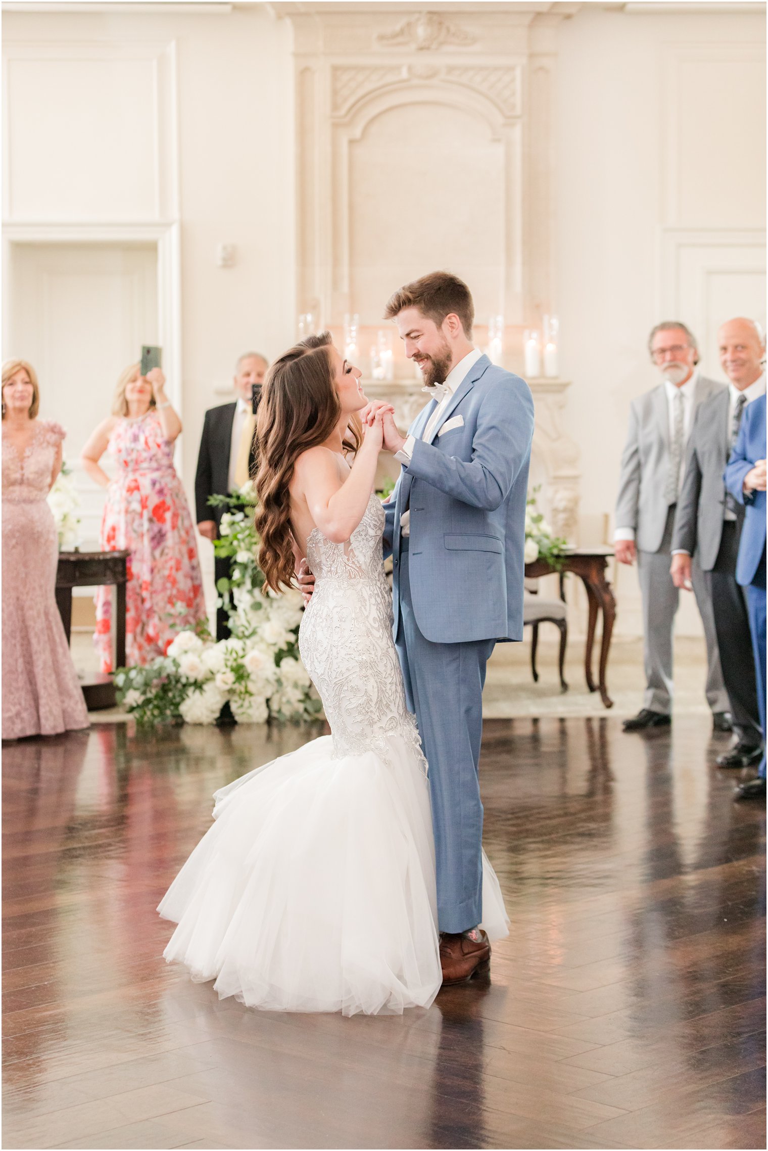 groom hugs bride to him during first dance at Park Chateau Estate wedding reception 