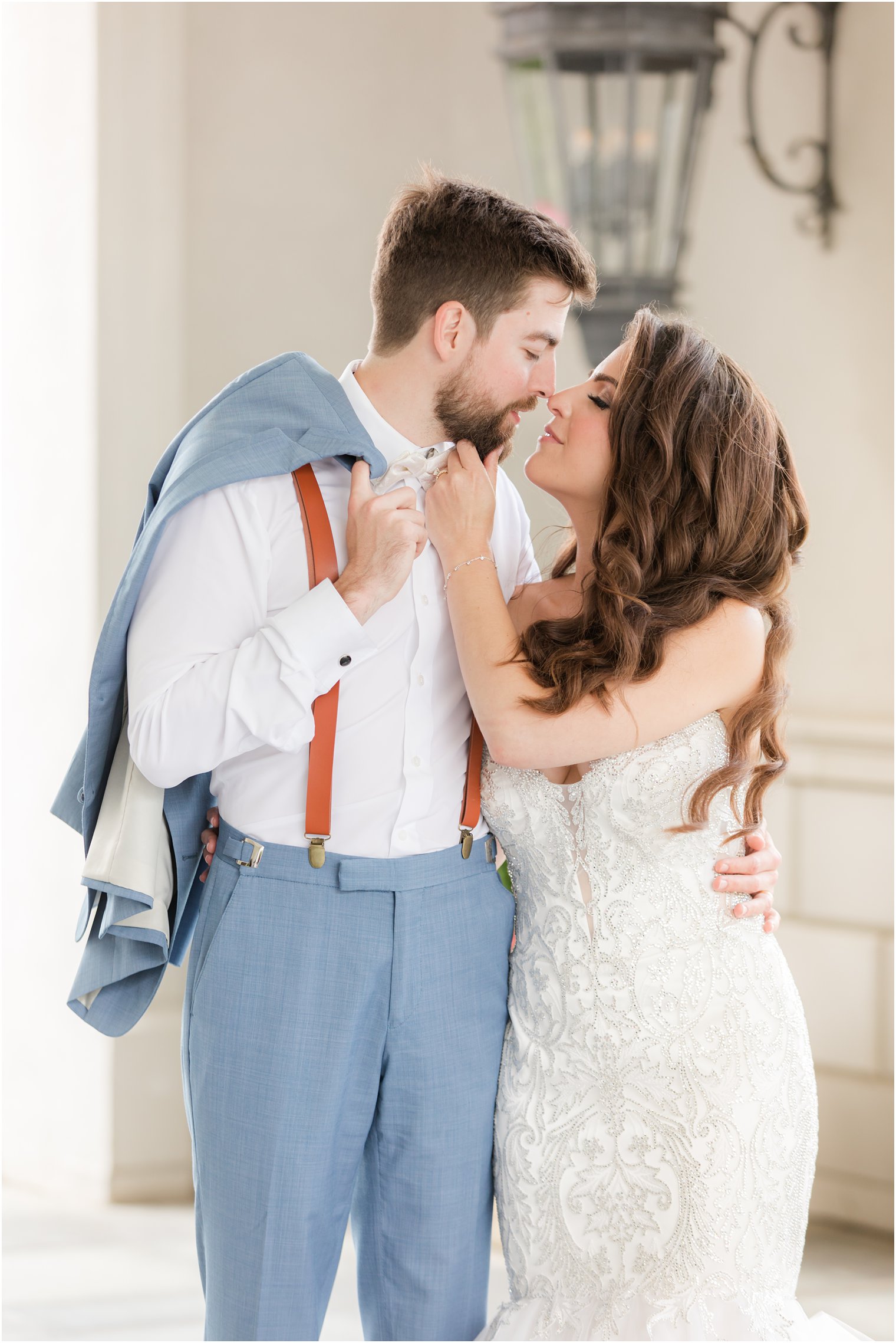 bride lenas to kiss groom holding his chin during NJ wedding day 