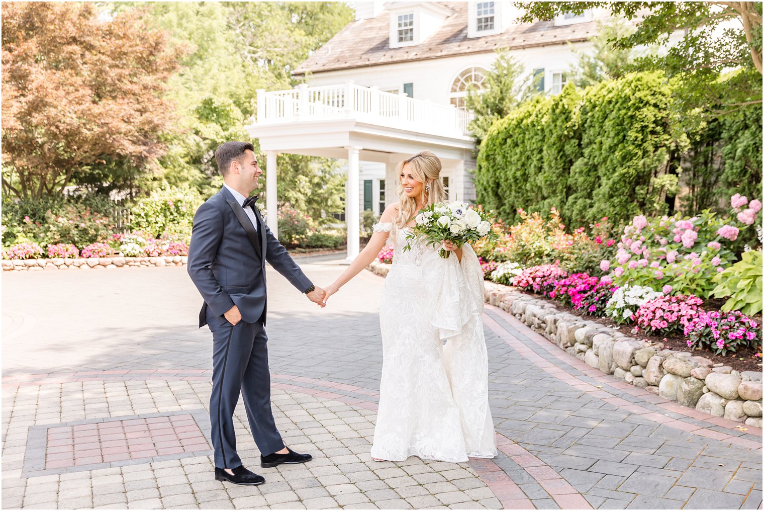 bride and groom hold hands walking in front of The English Manor