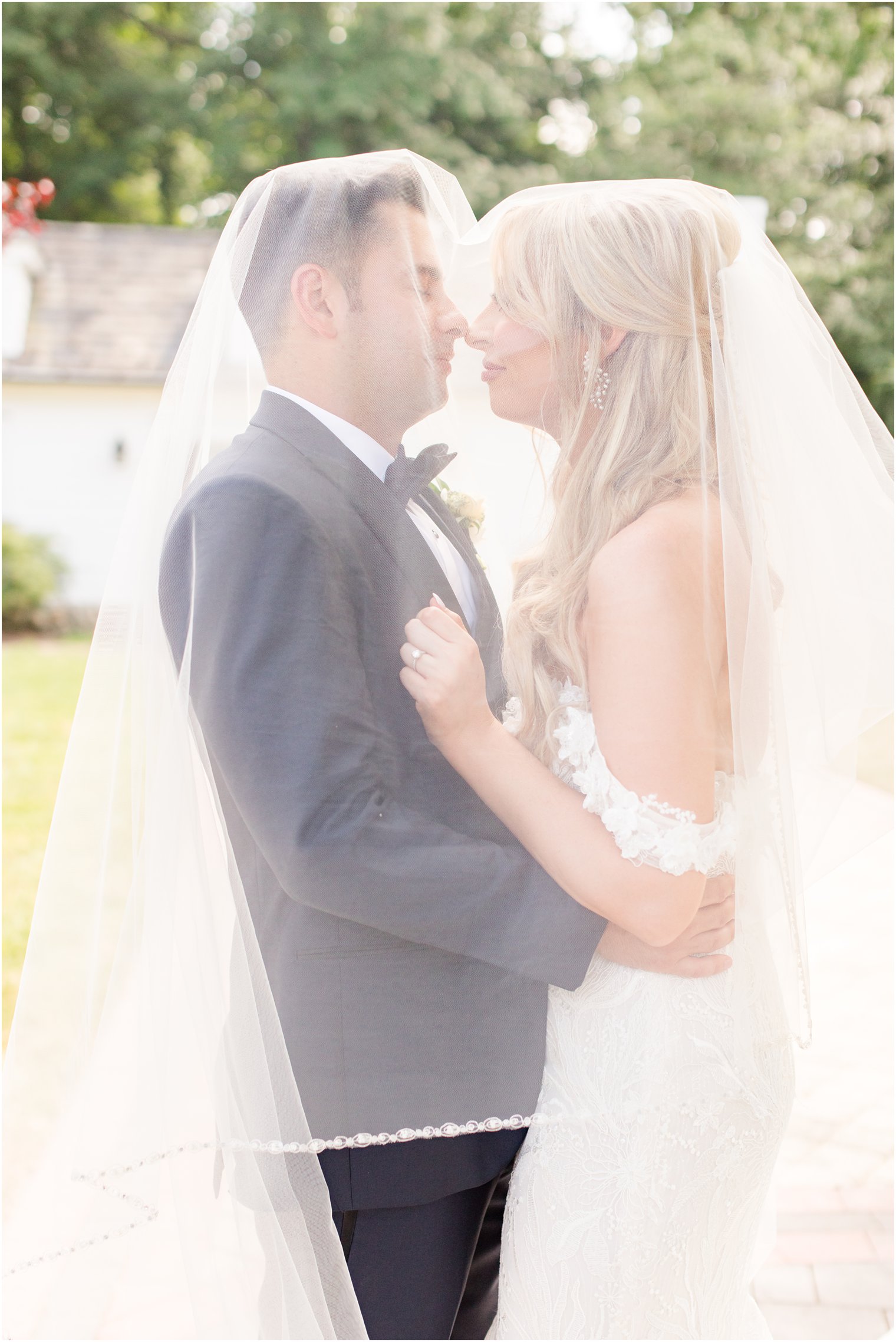 bride and groom nuzzle noses under veil during portraits at The English Manor