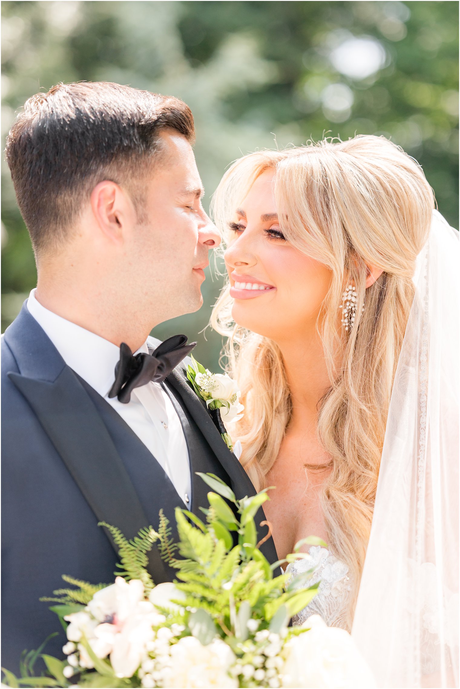 bride and groom smile together touching noses during New Jersey wedding portraits 