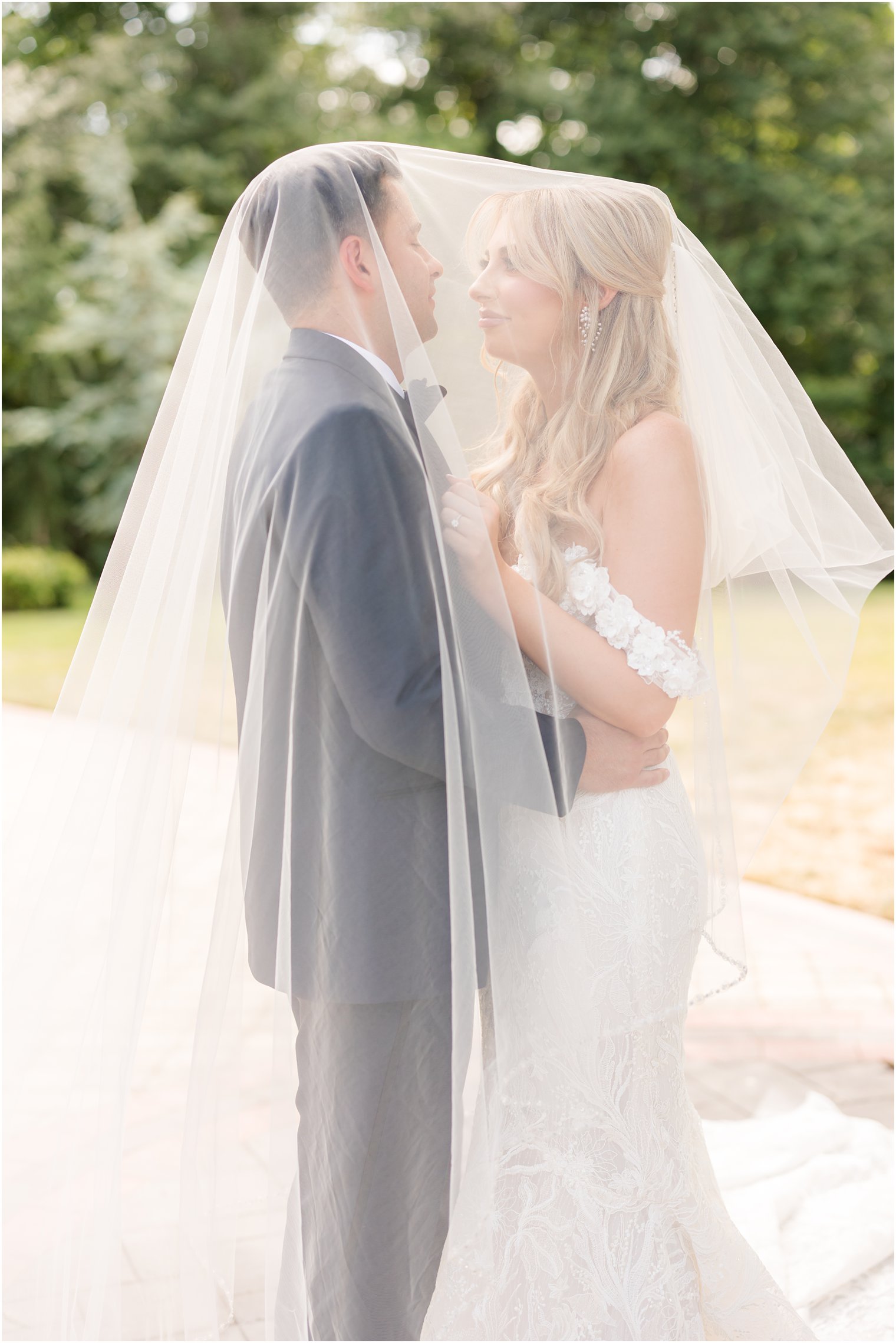bride and groom hug under bride's veil during portraits in New Jersey 