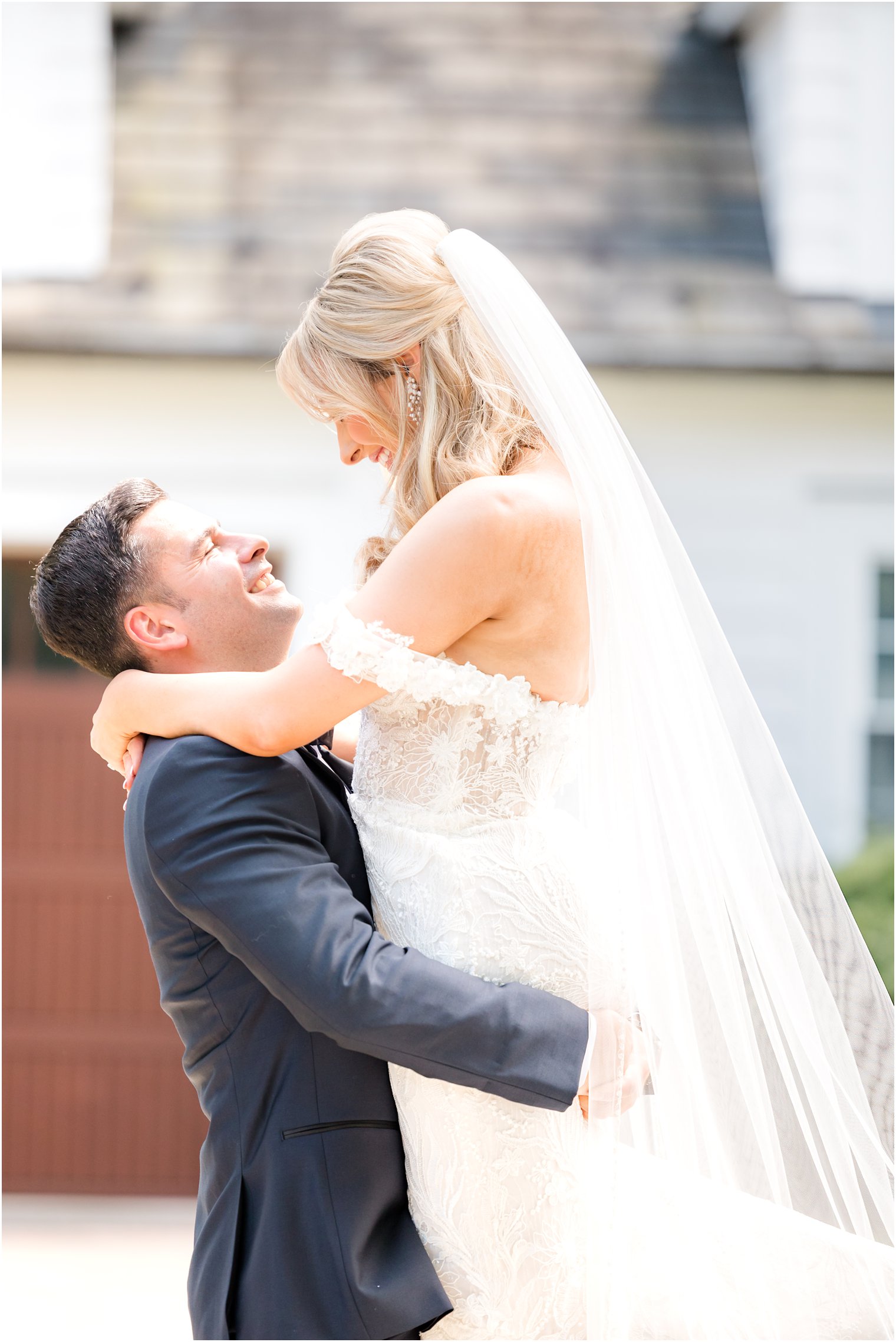 groom lifts bride in strapless gown during NJ wedding portraits 