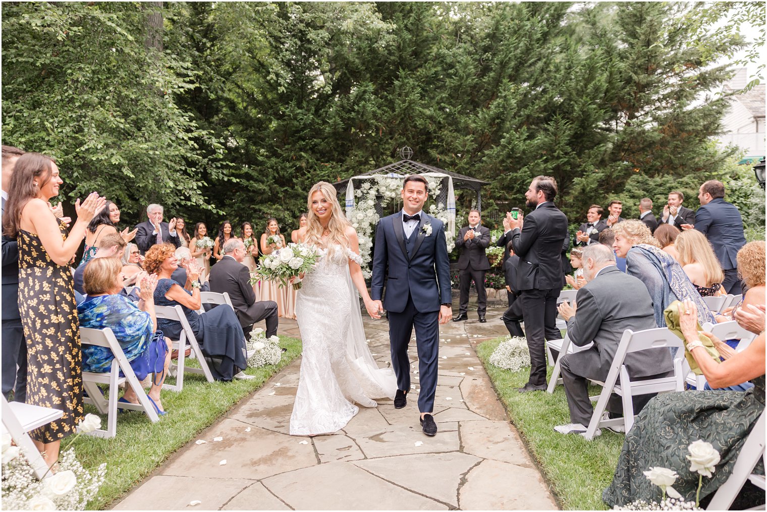 bride and groom hold hands walking up aisle at The English Manor 