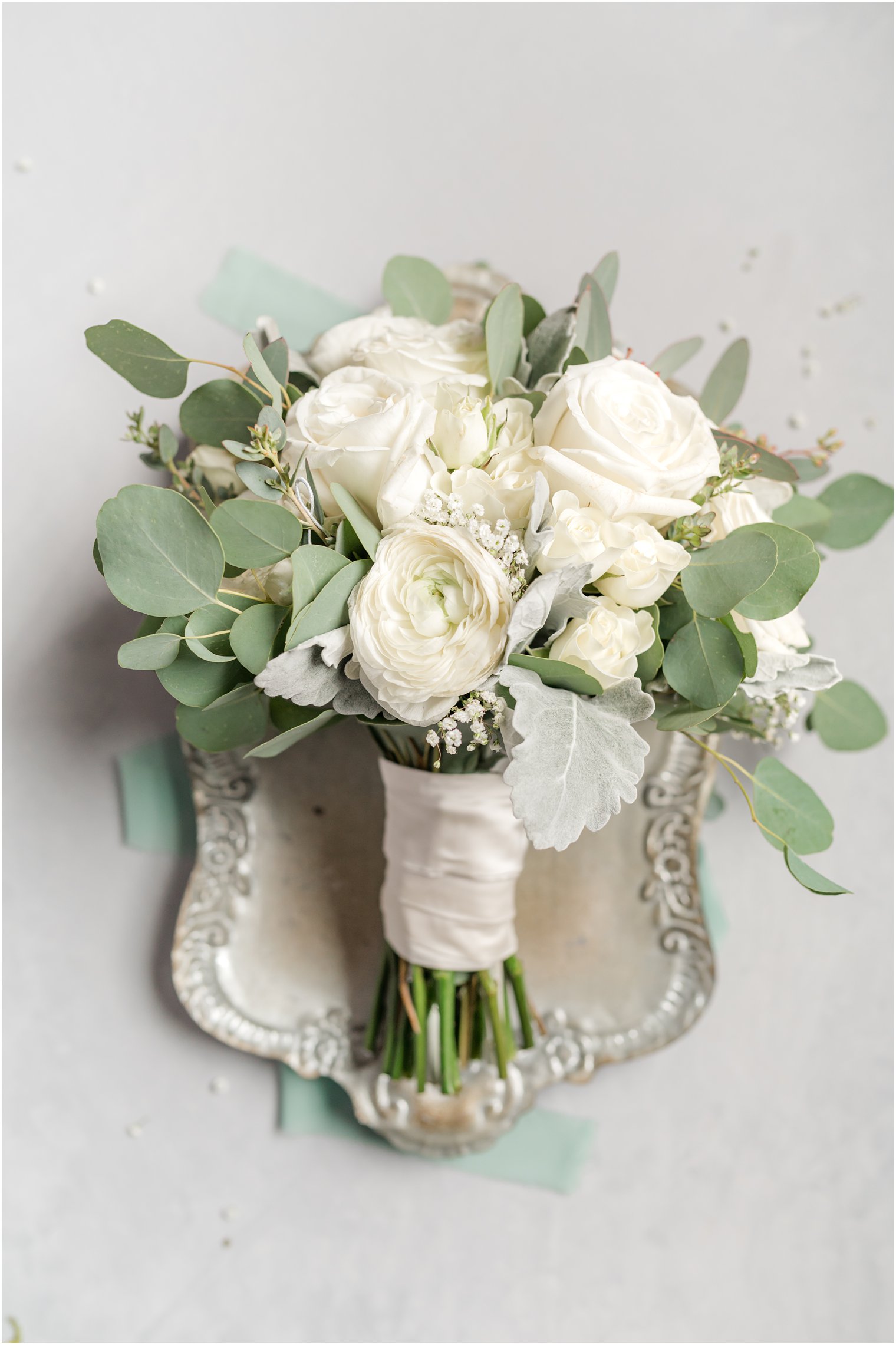 bride's all white rose bouquet on silver tray