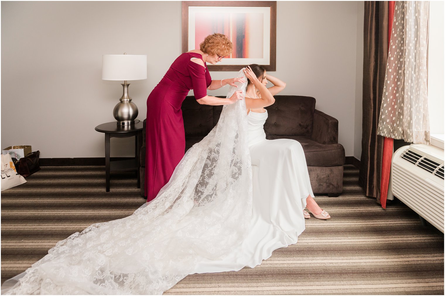 mother helps bride with veil in hotel room before NJ wedding 