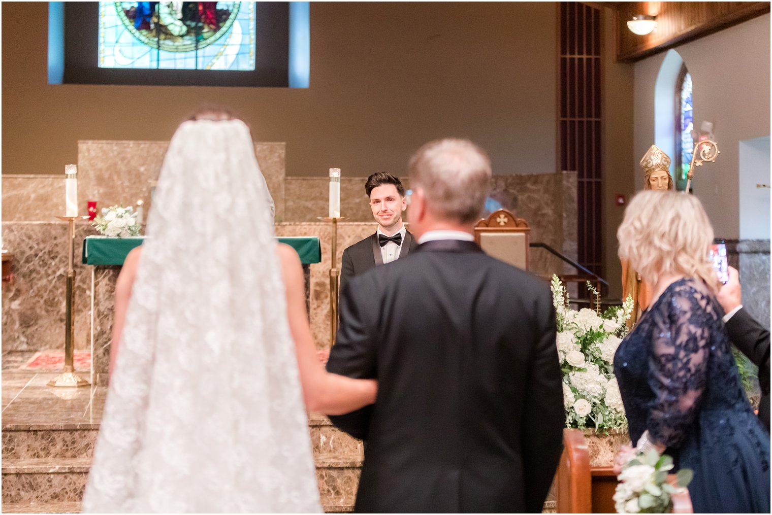 groom cries watching bride enter church for traditional church ceremony in small New Jersey church