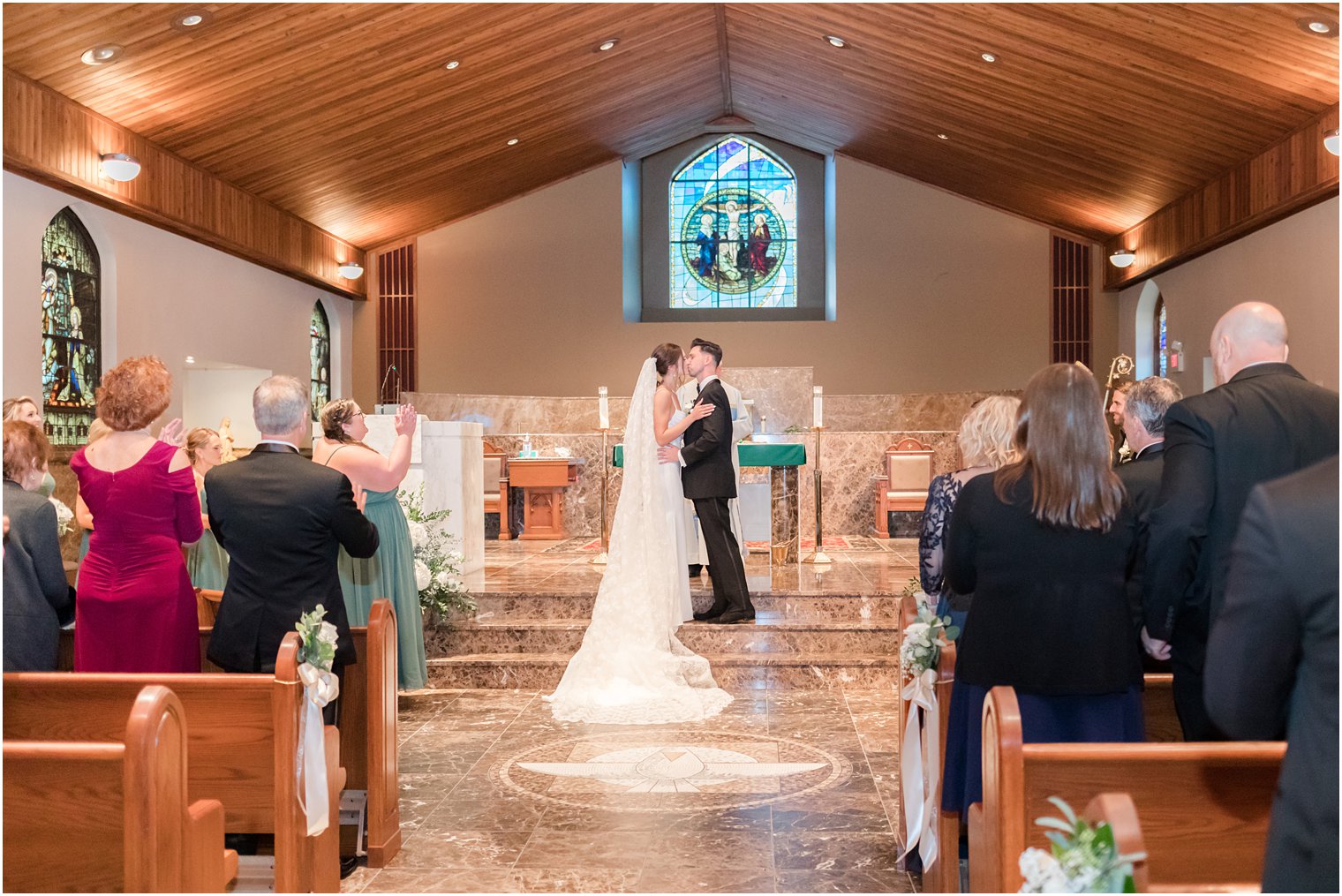 bride and groom kiss on alter during traditional church ceremony in small New Jersey church