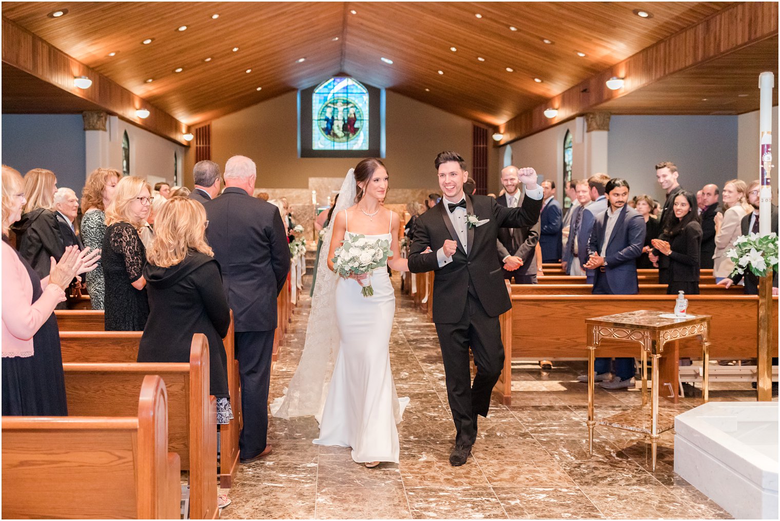 newlyweds cheer leaving traditional church ceremony in small New Jersey church