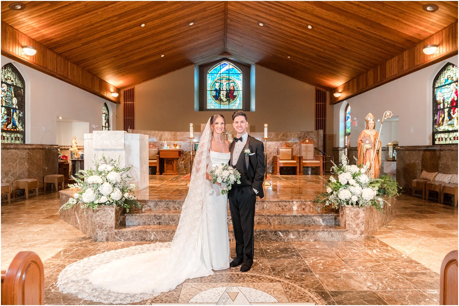 bride and groom pose in alter at church in New Jersey 