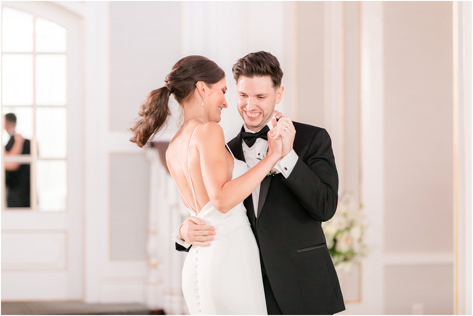 bride and groom smile during first dance in New Jersey ballroom 