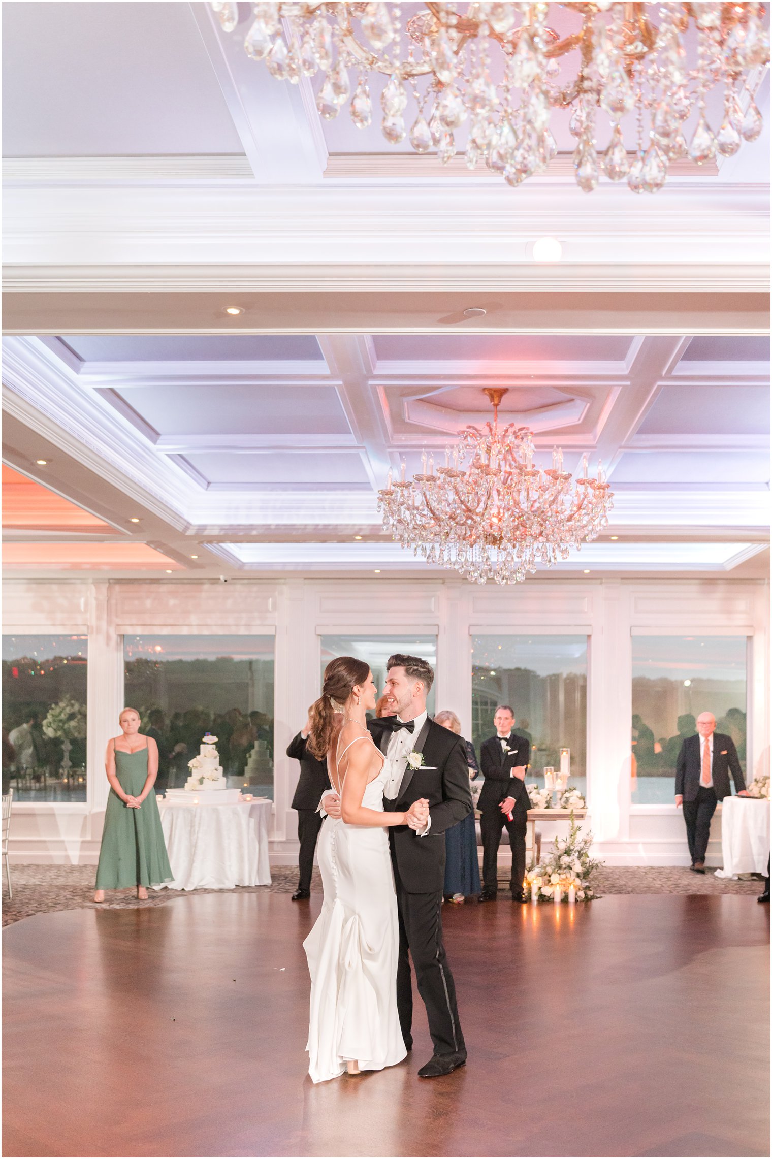 bride and groom dance under chandelier in ballroom at The Mill Lakeside Manor
