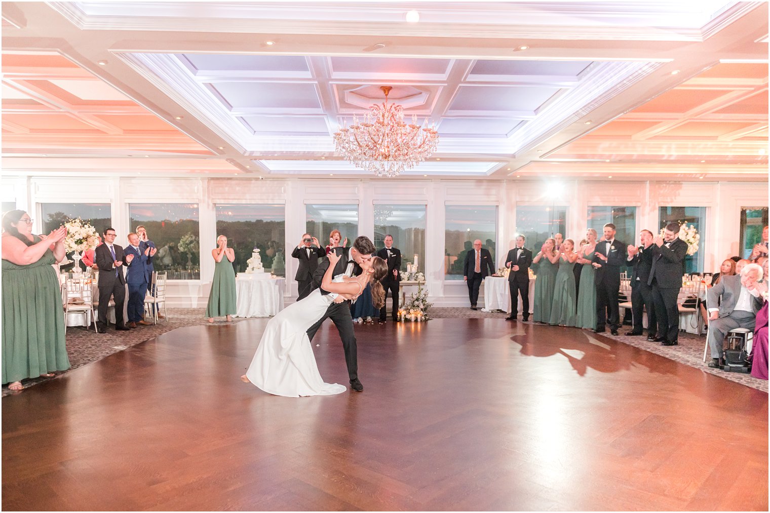 groom dips bride kissing her on dance floor in ballroom at The Mill Lakeside Manor