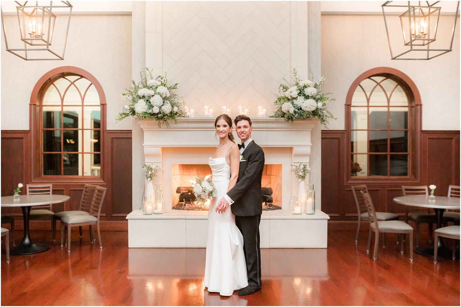 bride and groom stand in front of white fireplace during NJ wedding portraits 