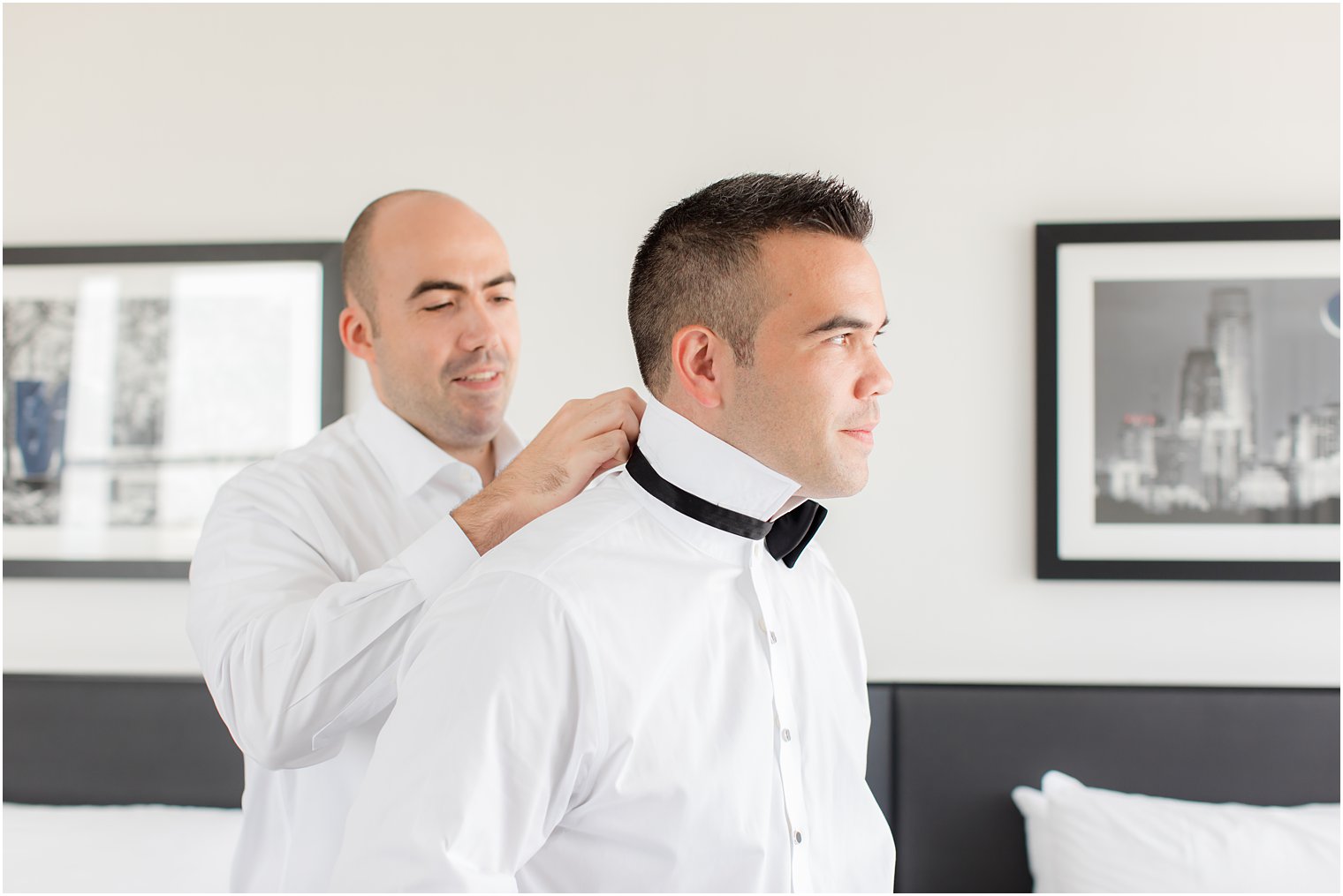 man helps groom with black bowtie for Philly wedding 