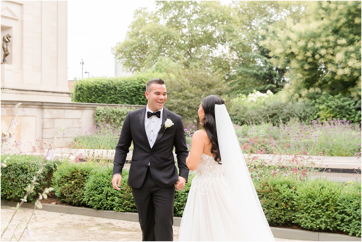groom in black tux turns to see bride during first look 
