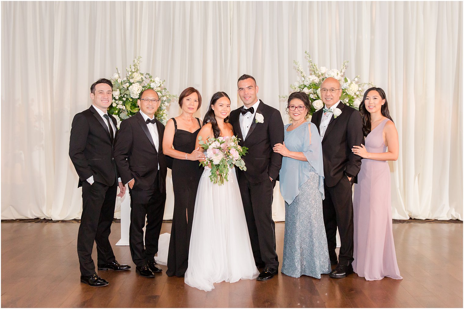 bride and groom pose with family at the Ballroom at the Ben