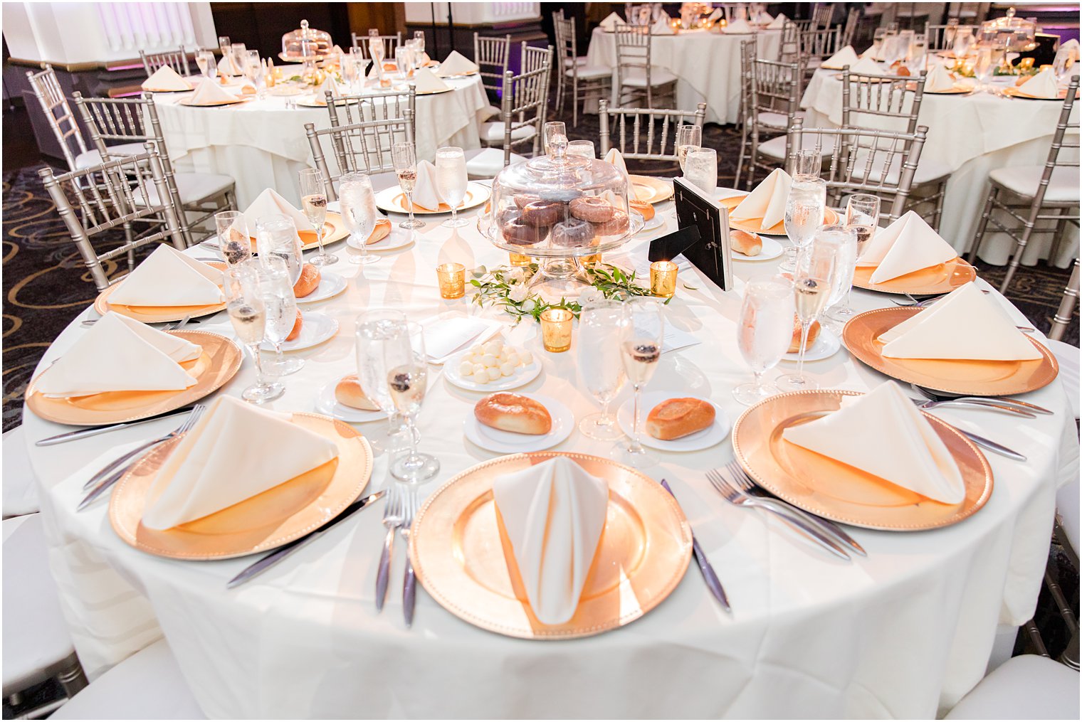 gold plates and ivory napkins on table at the Ballroom at the Ben