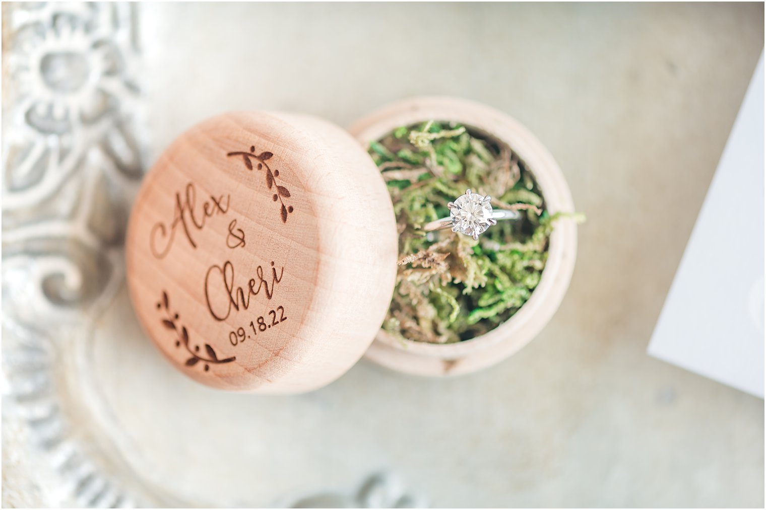 wedding rings rest in wooden box with green grass