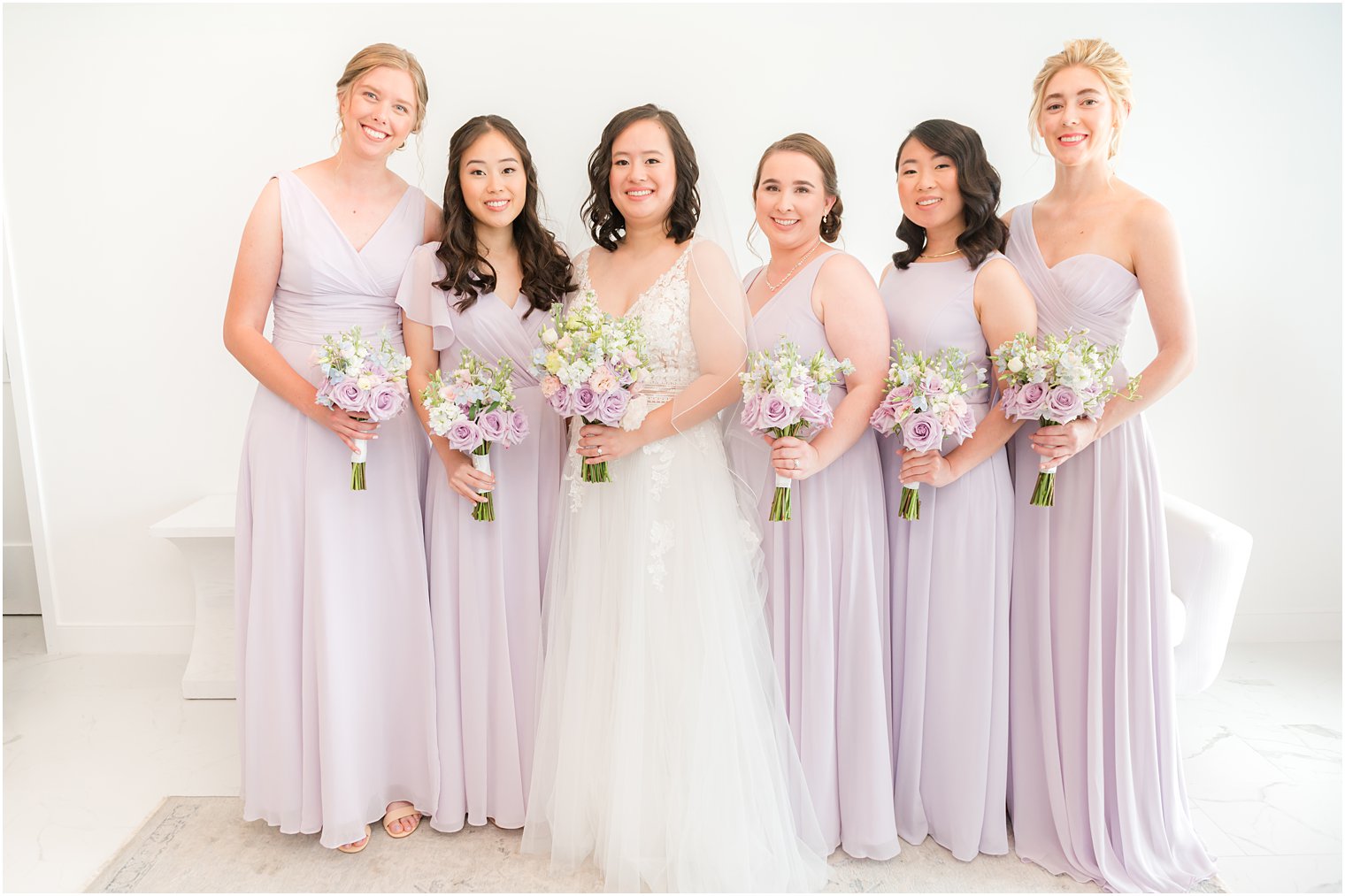 bride stands with bridesmaids in purple gowns at Icona Winddrift