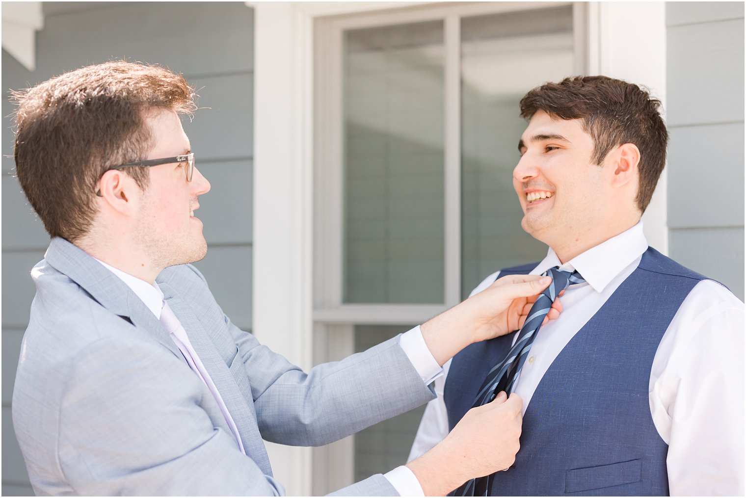 groomsman adjusts tie for groom before Avalon NJ wedding