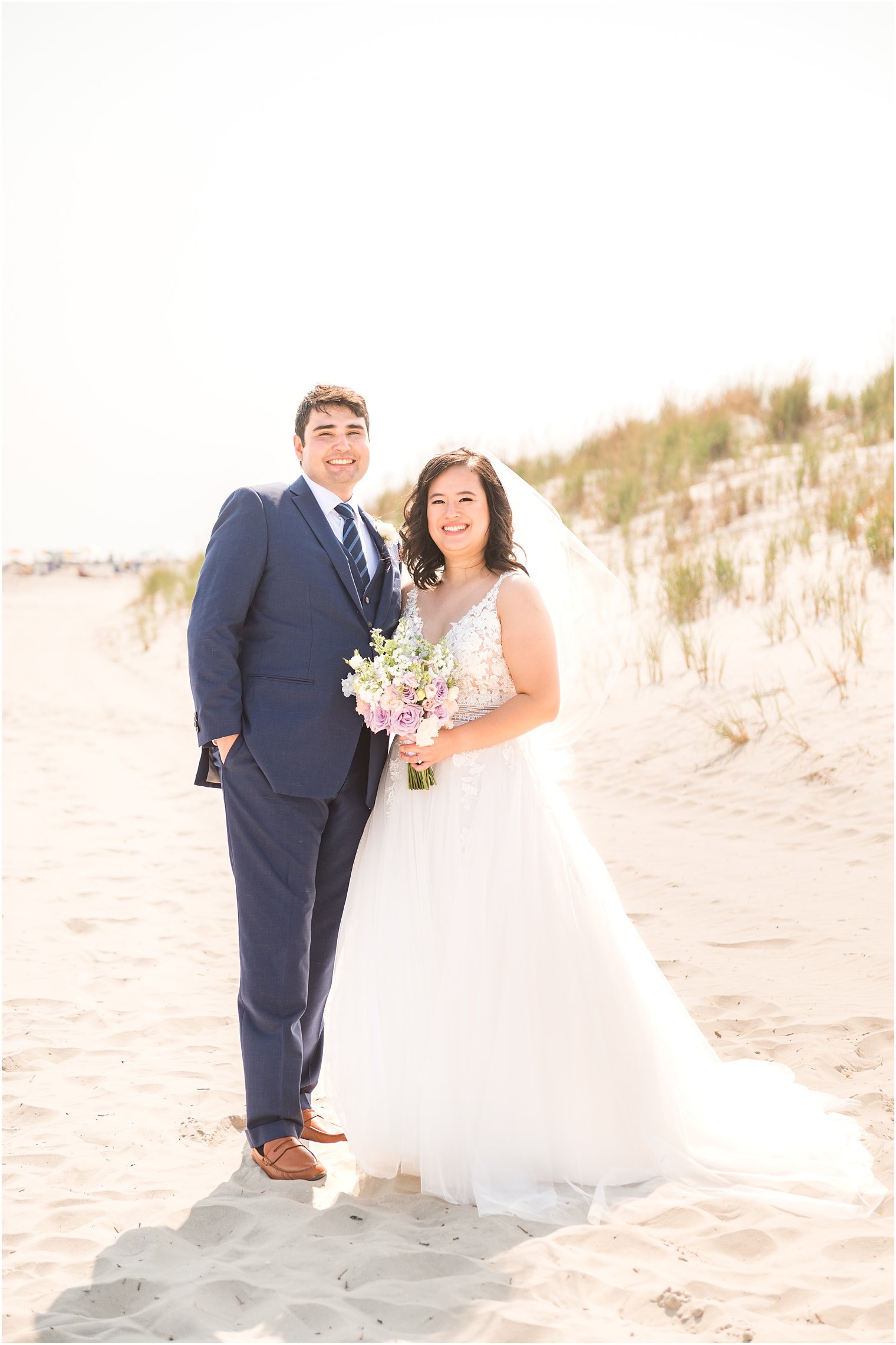 newlyweds stand together on sand dune near Icona Winddrift