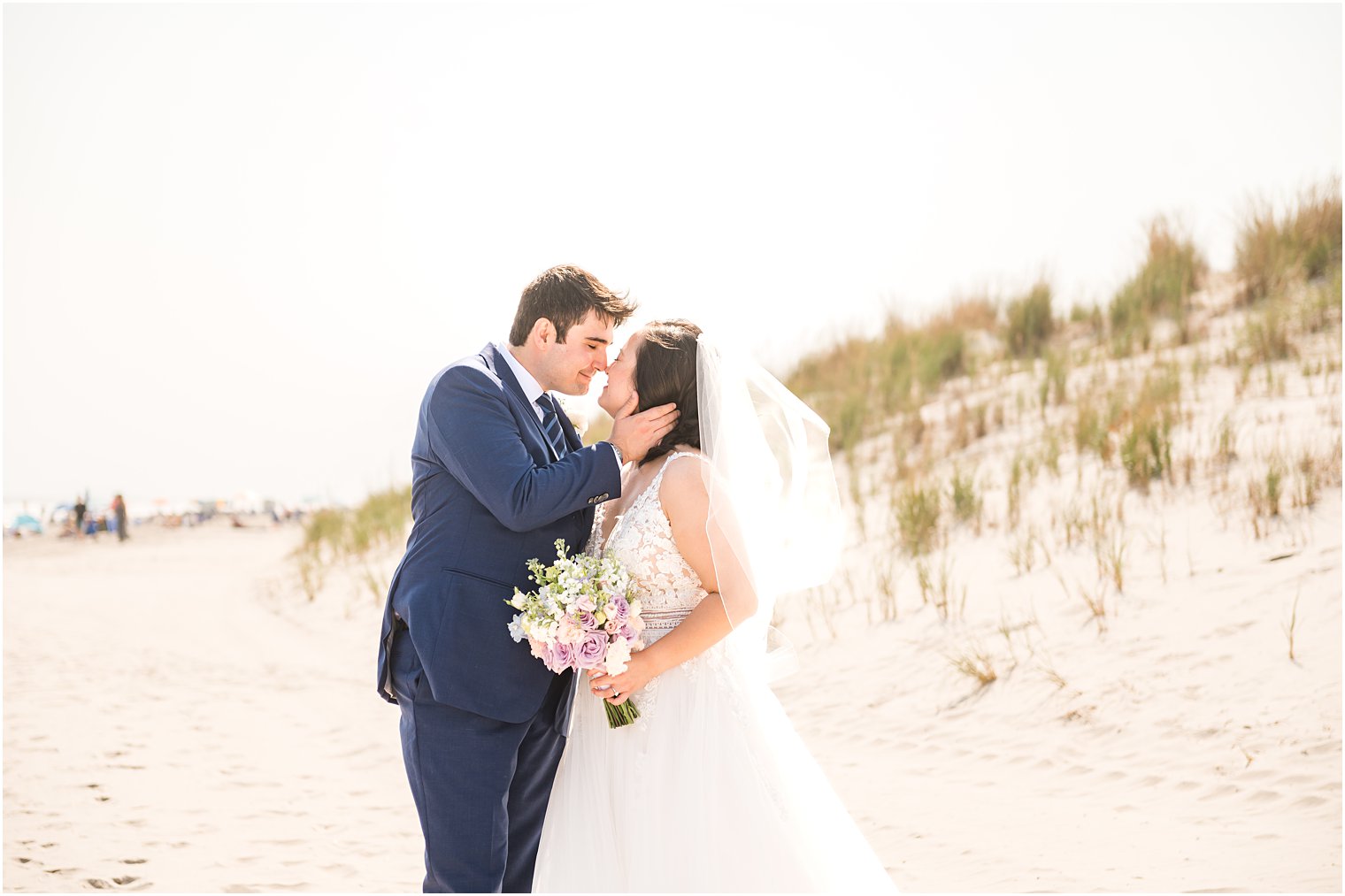 groom leans to nuzzle bride's nose during beach wedding portraits 