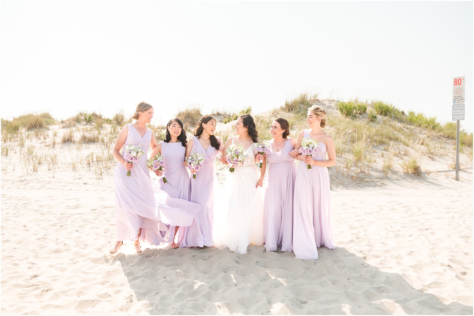 bride walks with bridesmaids in purple gowns at Icona Winddrift