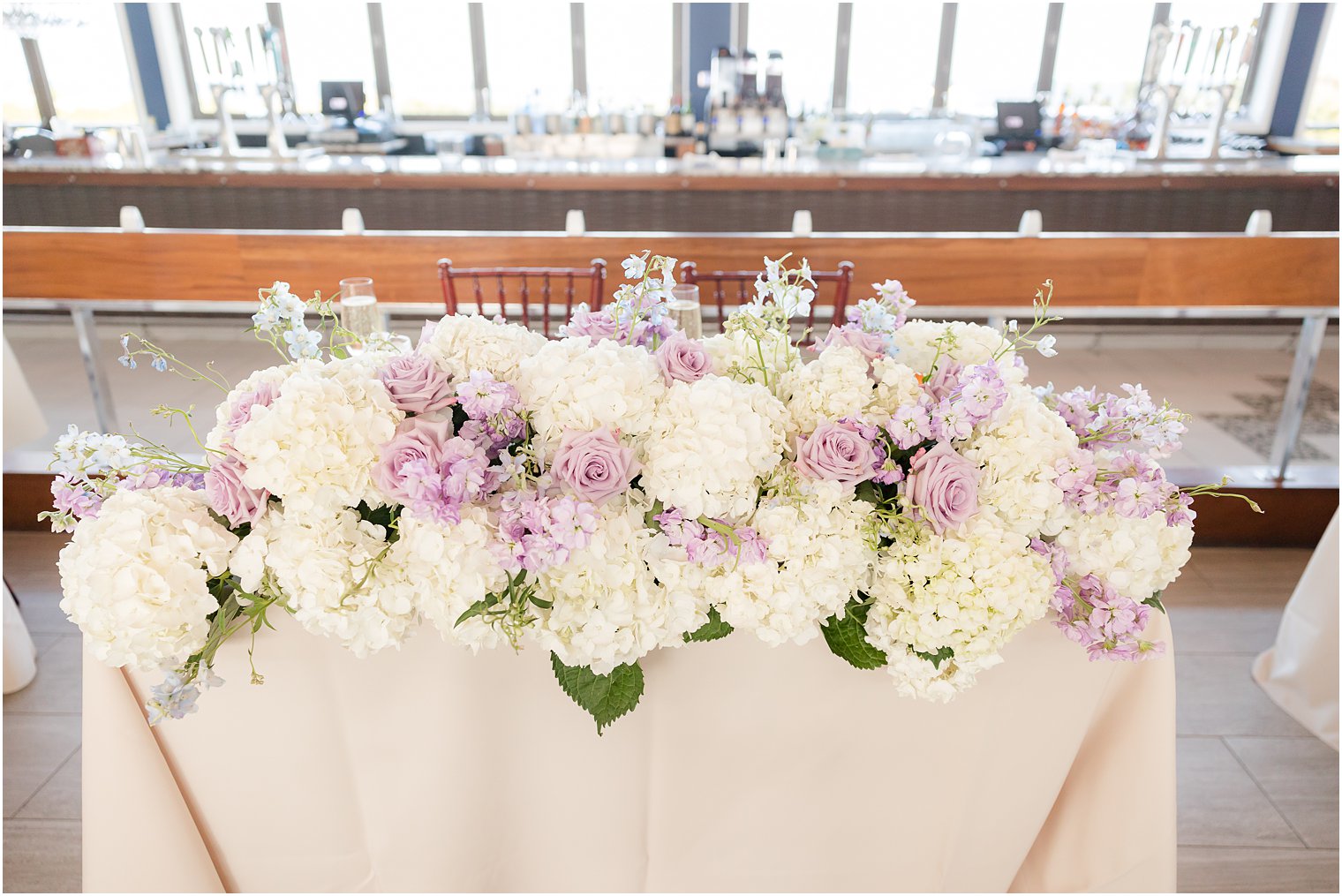 white and purple floral accent on sweetheart table 