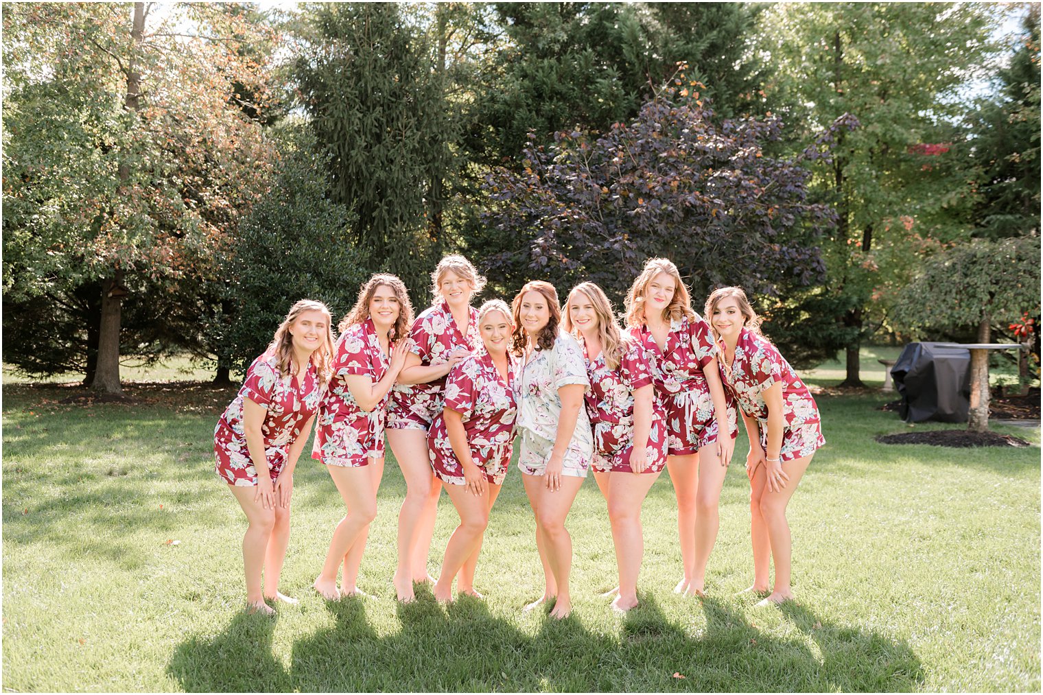 bride poses with bridesmaids in matching robes at Bishop Hall Farmstead