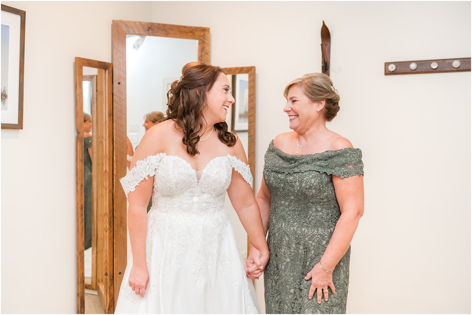 mother in green dress smiles at bride during prep at Bishop Hall Farmstead