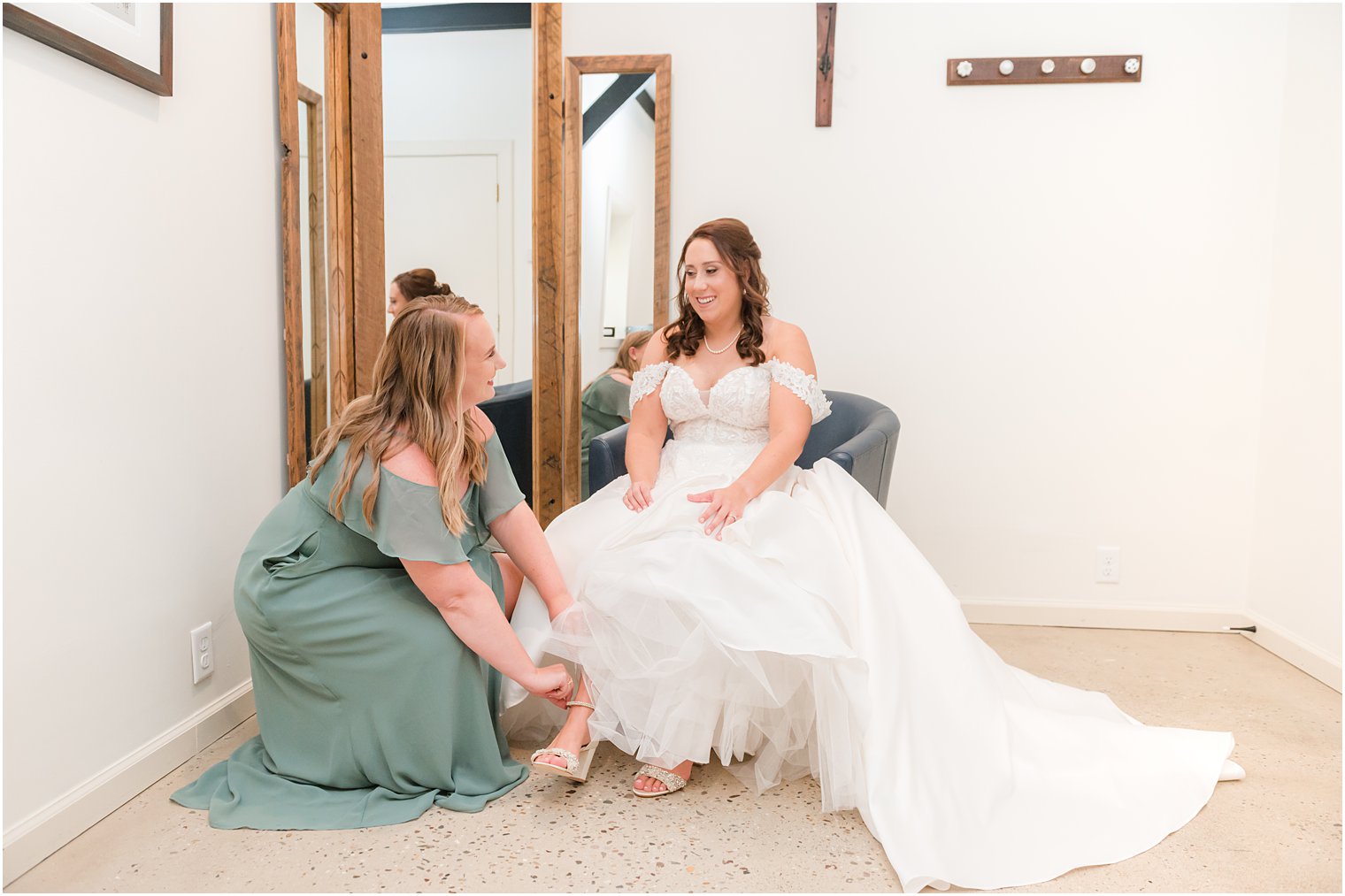 bridesmaid helps bride into shoes for fall wedding day