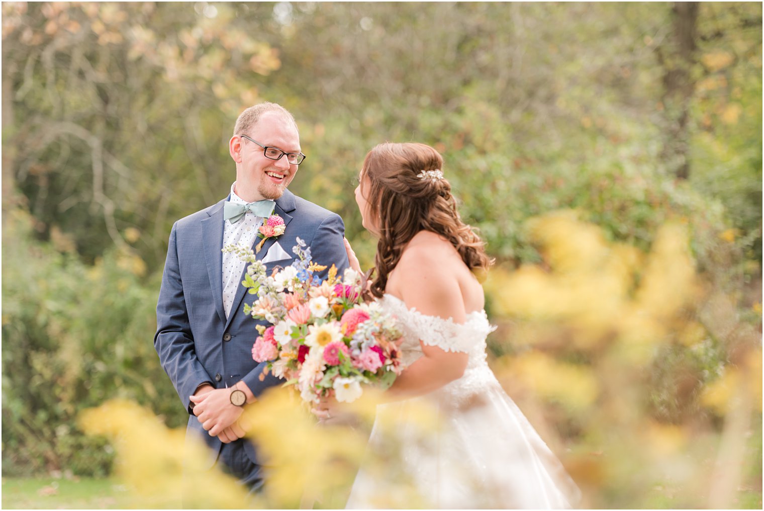 groom smiles at bride during first look on lawn at Bishop Hall Farmstead