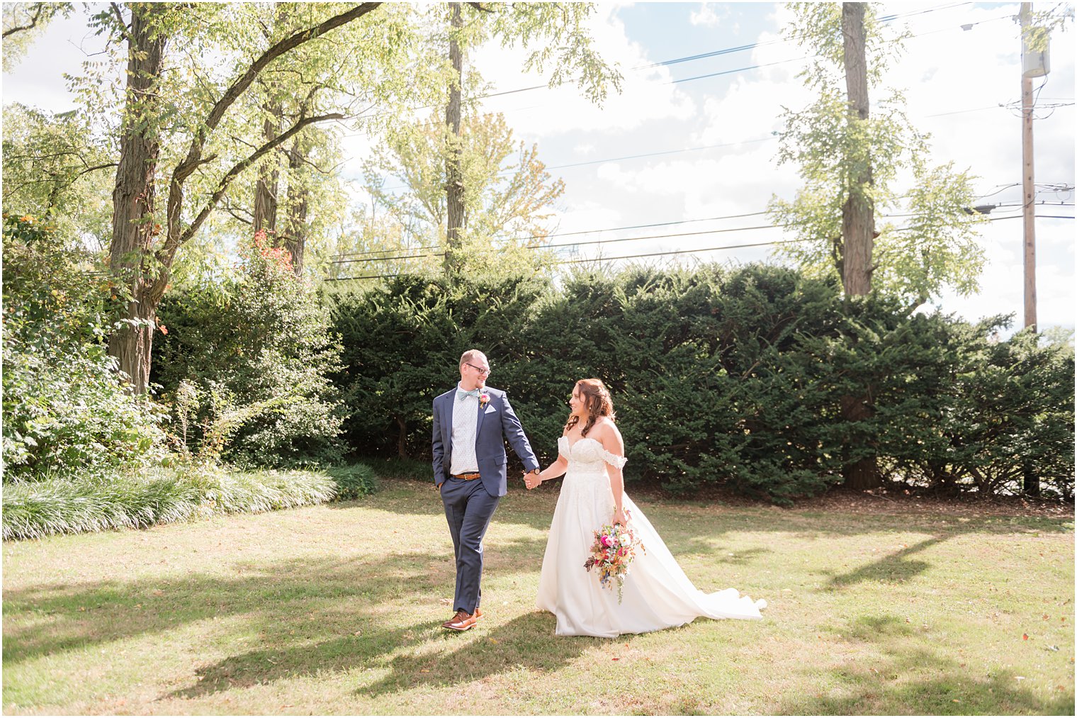 bride and groom hold hands walking on lawn at Bishop Hall Farmstead