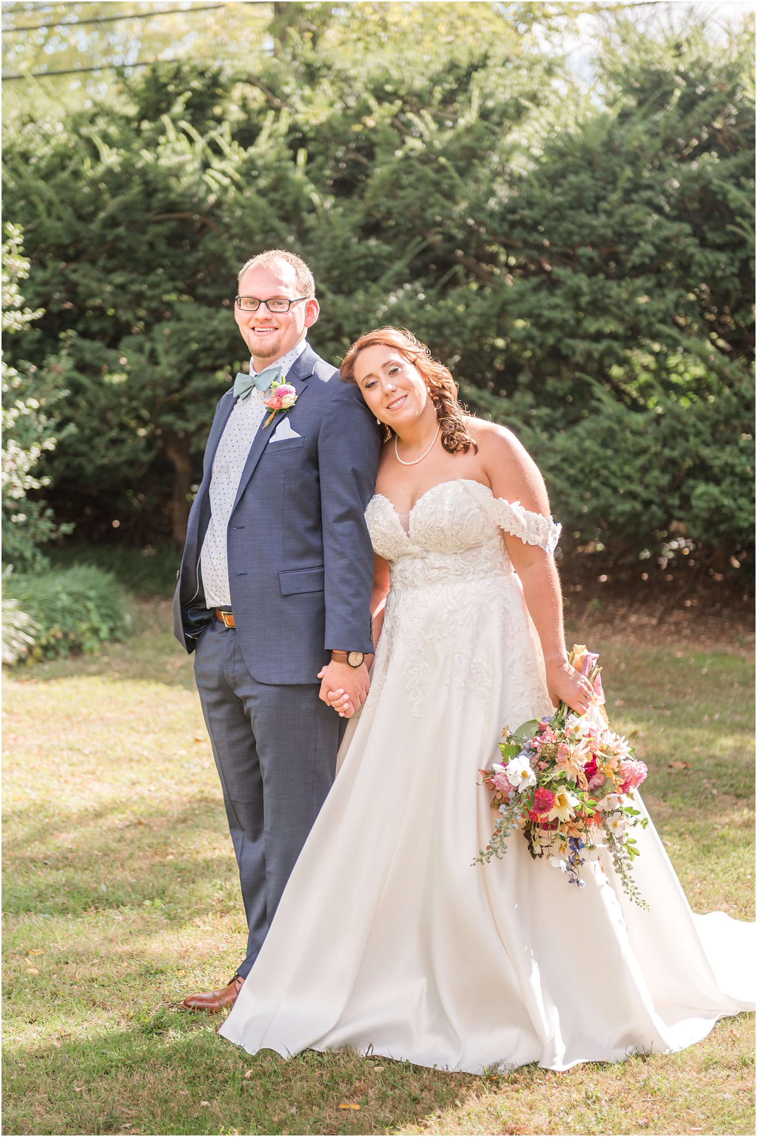 bride leans head on groom's shoulder standing together at Bishop Hall Farmstead