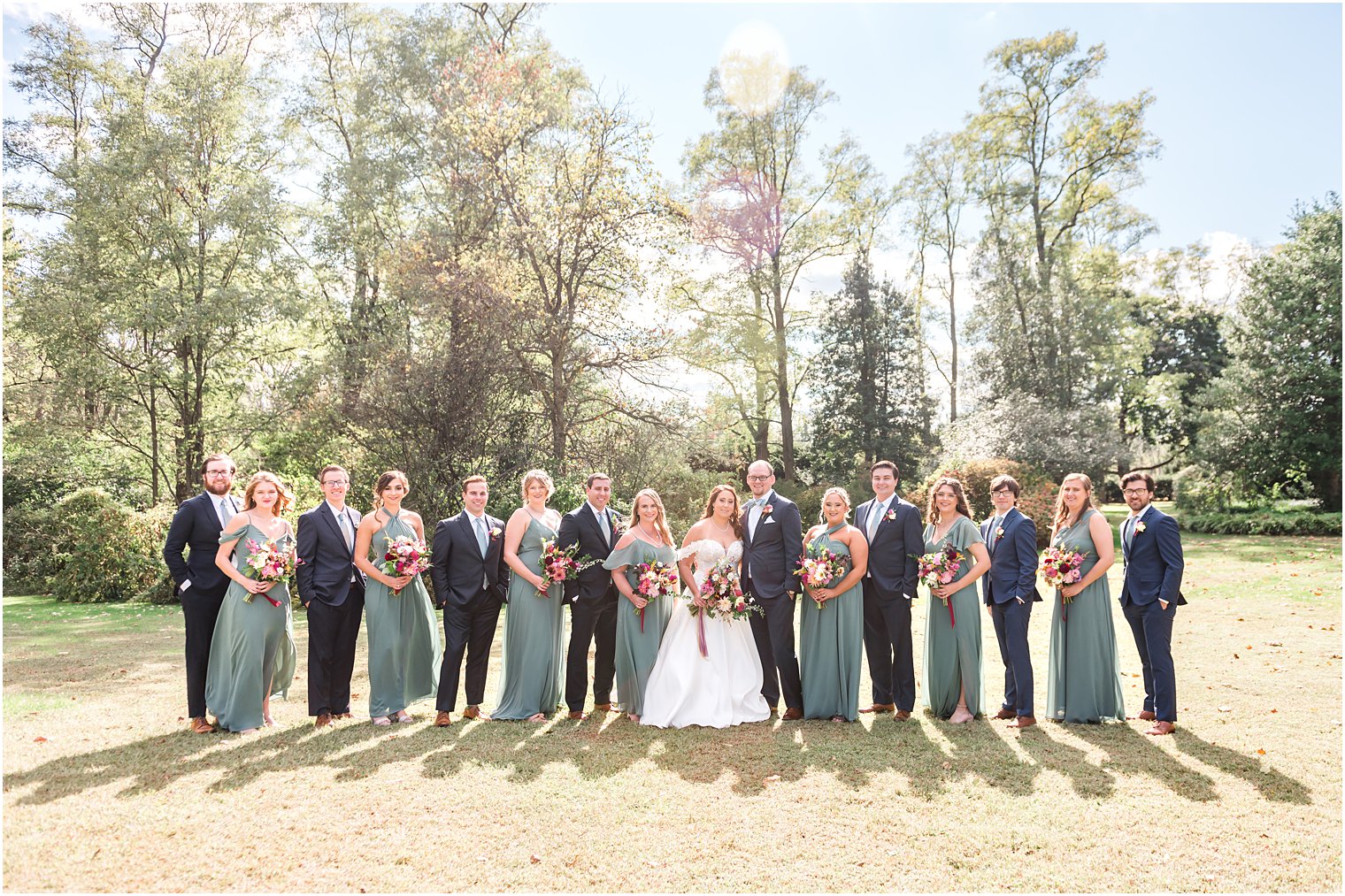 bride and groom stands with wedding party on lawn at Bishop Hall Farmstead
