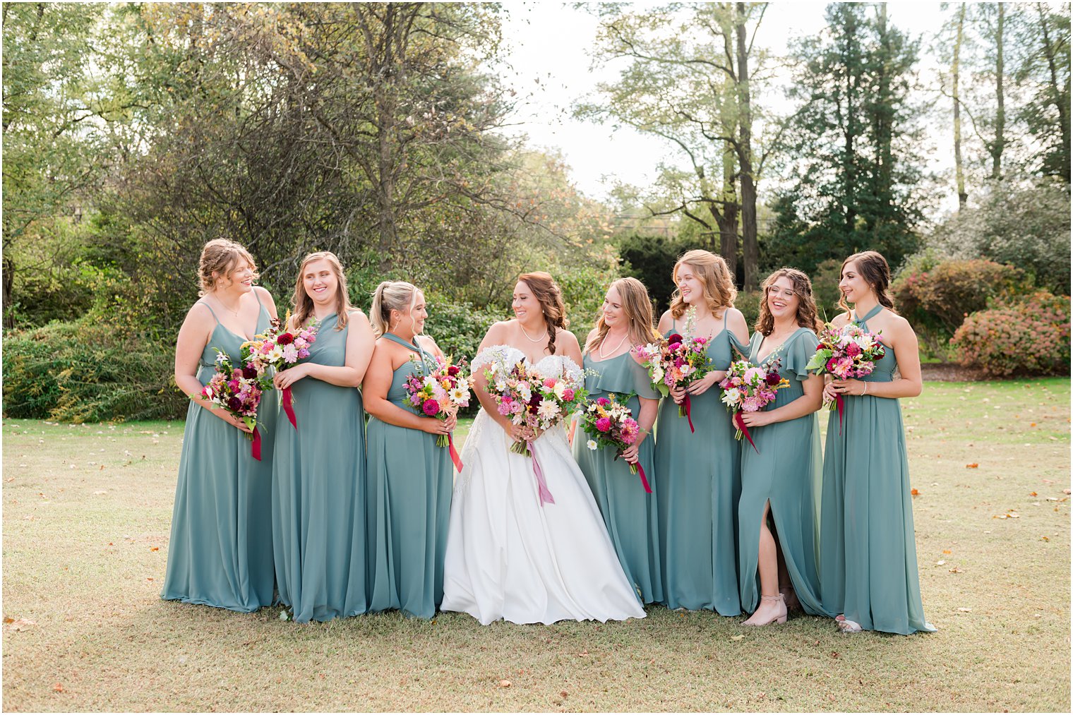 bride laughs with bridesmaids in sea glass green gowns at Bishop Hall Farmstead