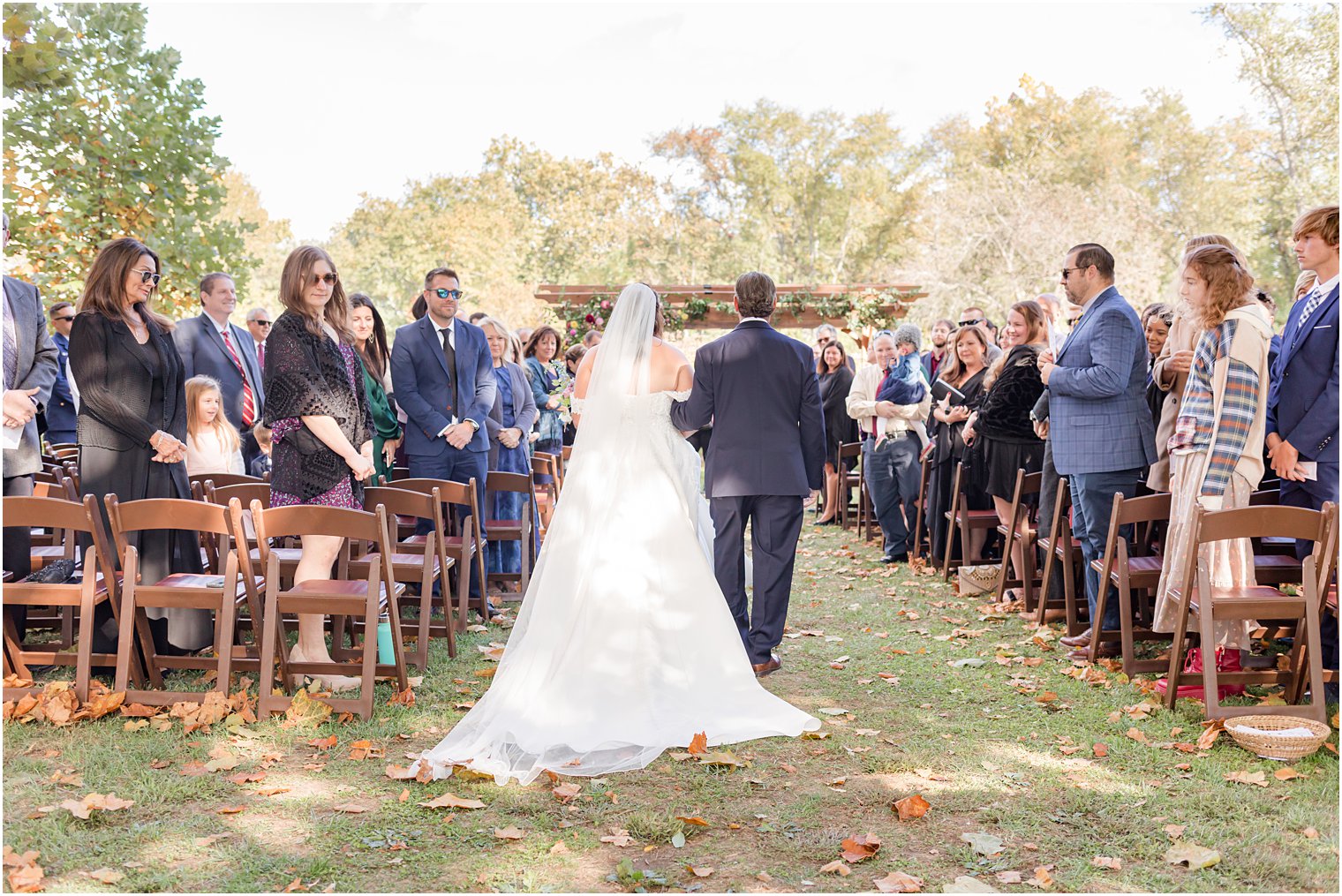 bride and father walk into fall wedding ceremony outdoors on lawn at Bishop Hall Farmstead