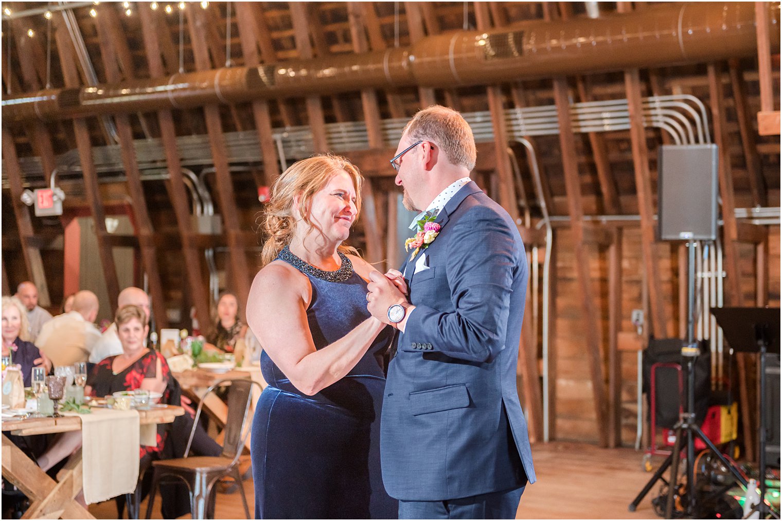 groom dances with mother during barn reception at Bishop Hall Farmstead