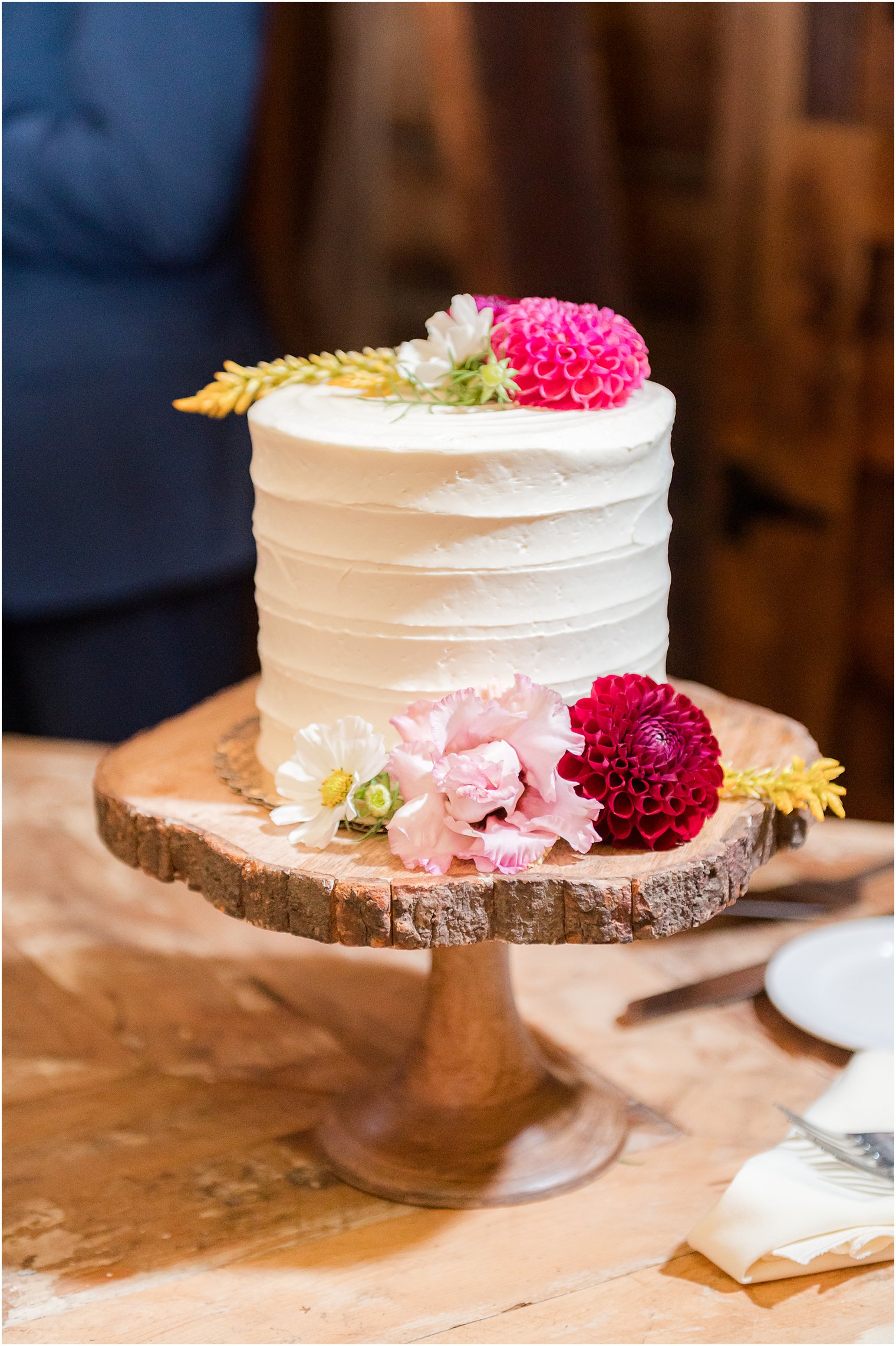wedding cake with wildflowers and rustic cake stand